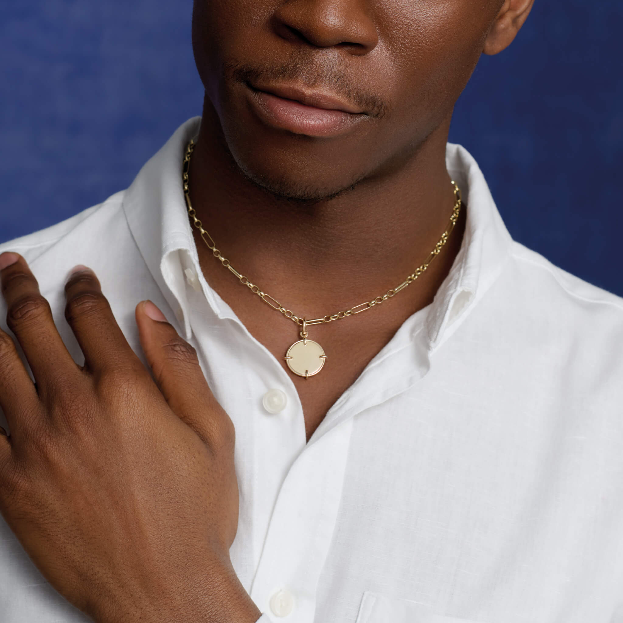 Model wearing a handcrafted engravable round precious metal necklace pendant.