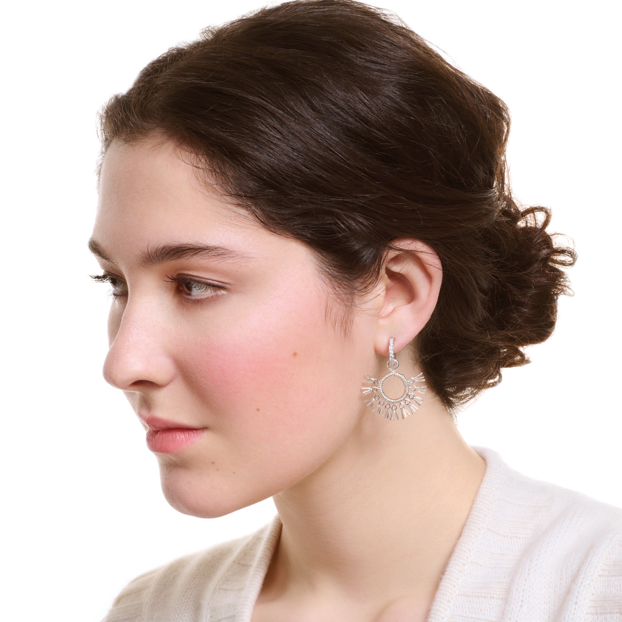 Model wearing handcrafted sterling silver earrings drops in the shape of dried palm fronds from Morocco.