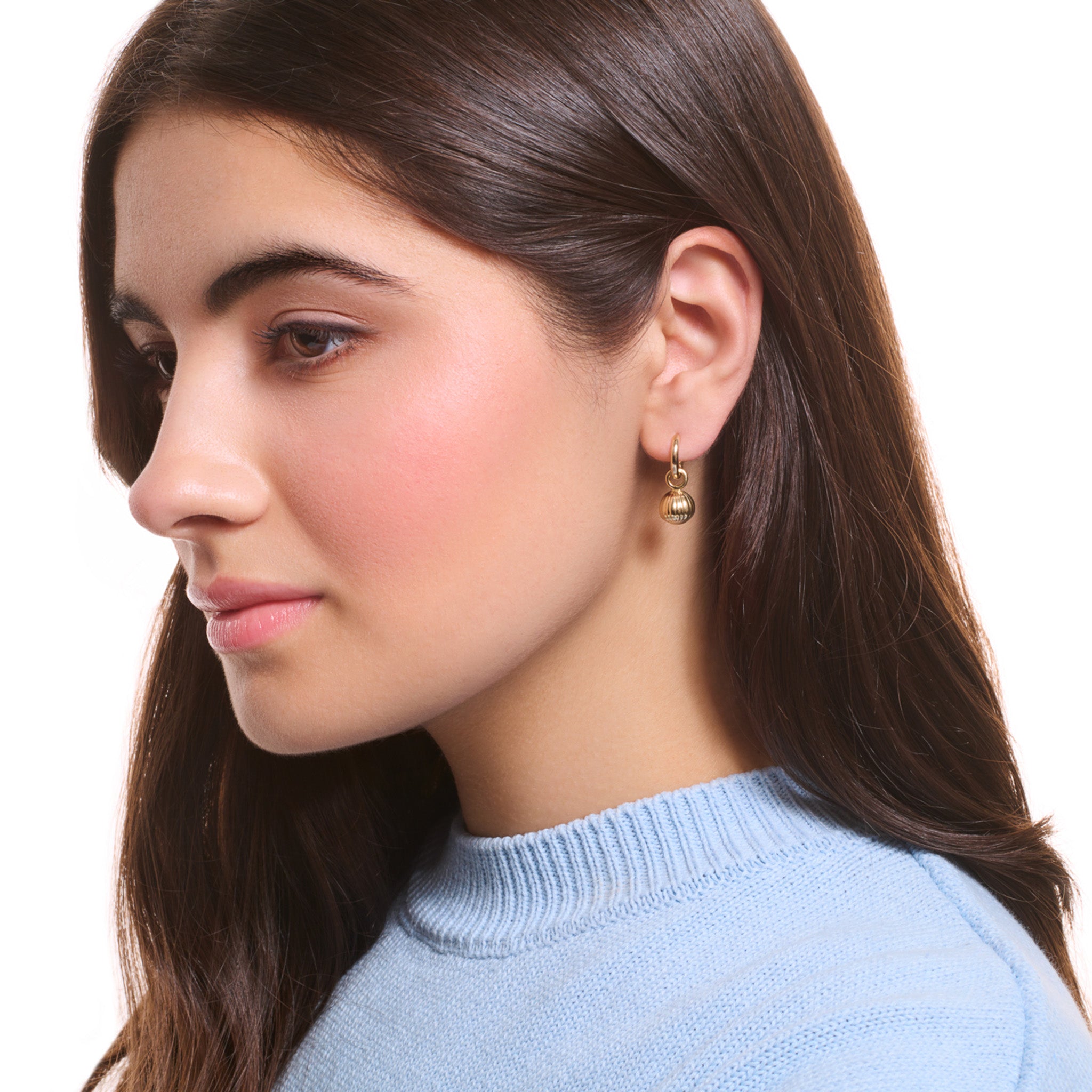 Model wearing handcrafted precious metal earring drops with a hazelnut design.