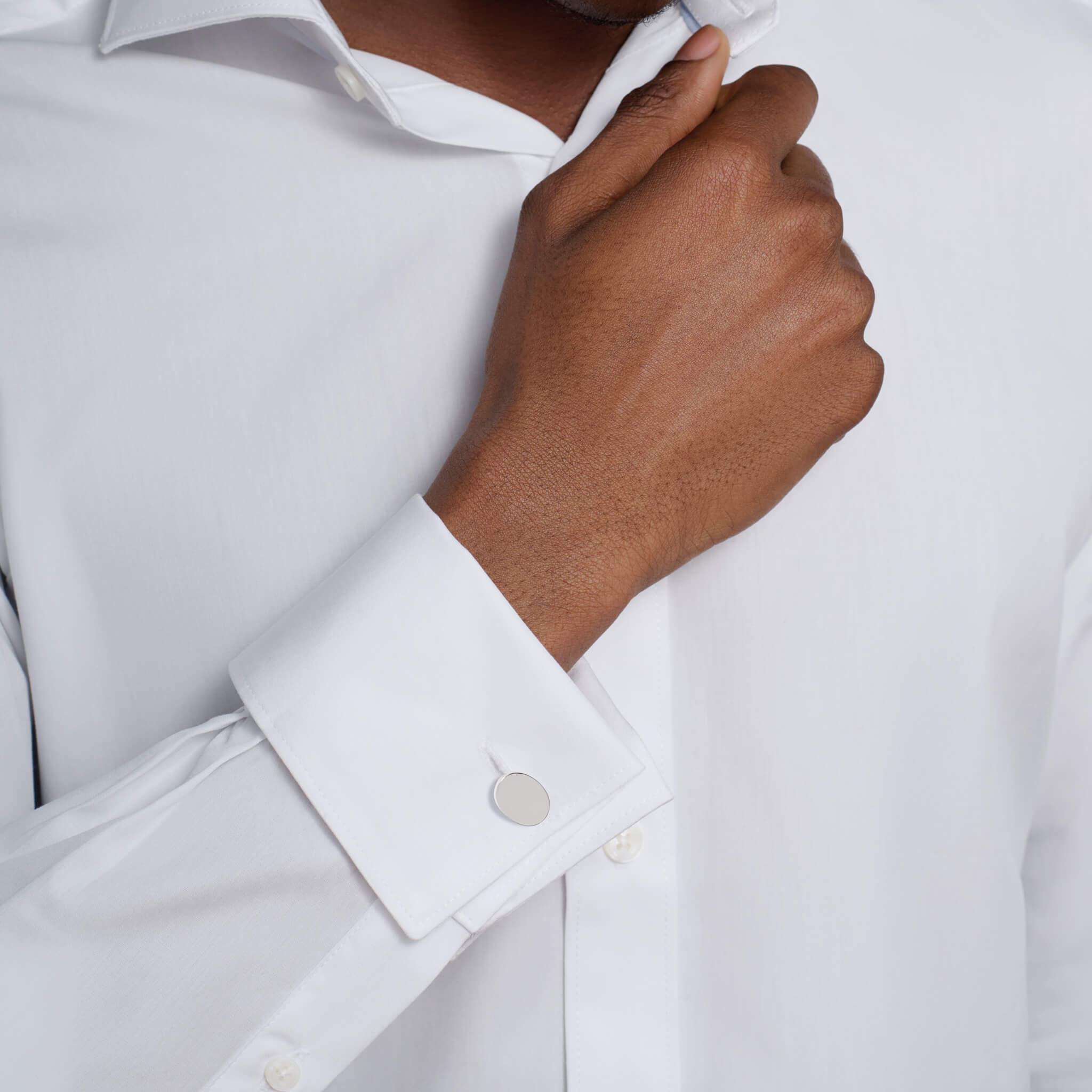 Model wears handcrafted sterling silver double ended cufflinks featuring a plain oval shape.