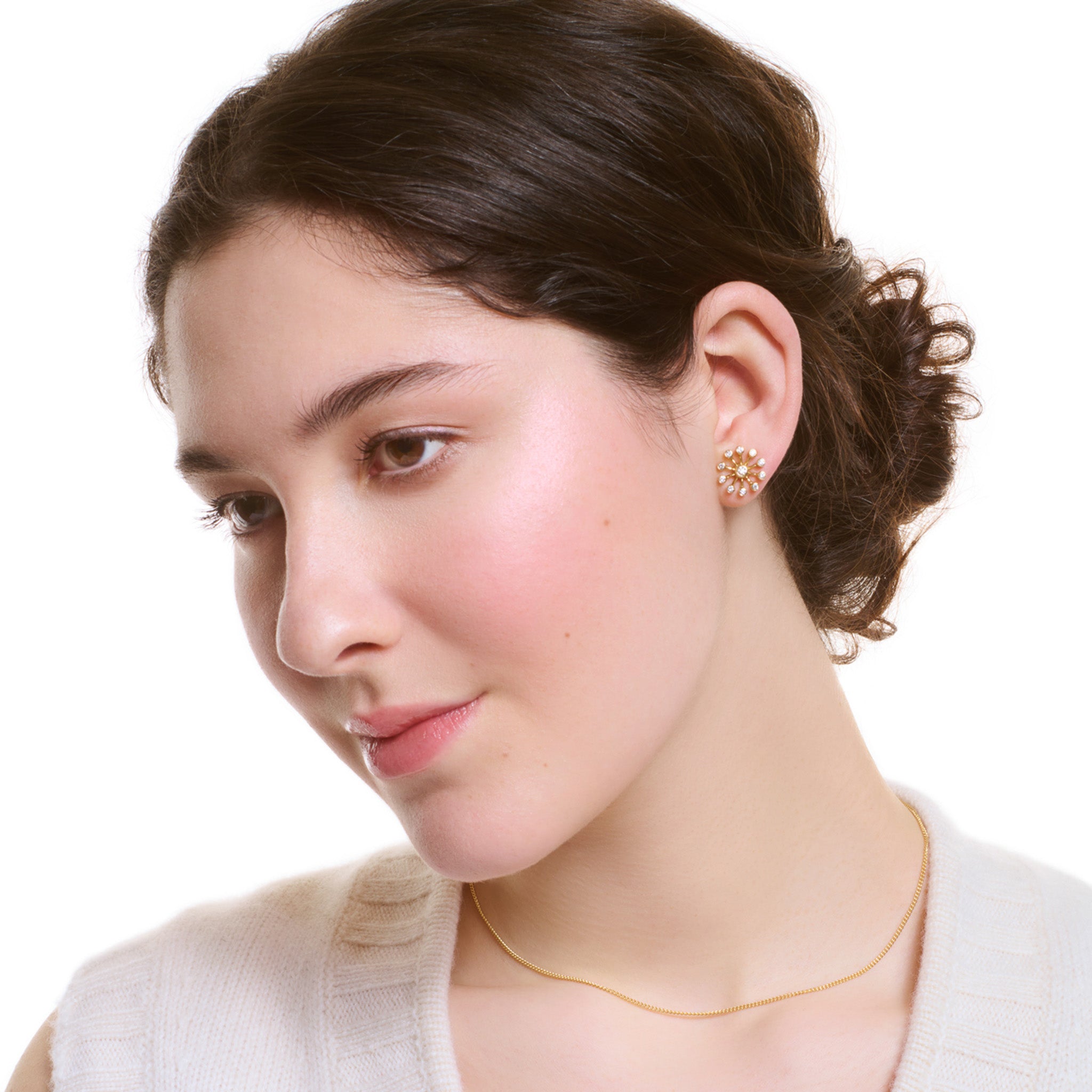 Model wearing handcrafted 18ct yellow gold necklace pendant inspired by the delicate spurs of an astrantia flower, with diamonds set at the tip of each spur.