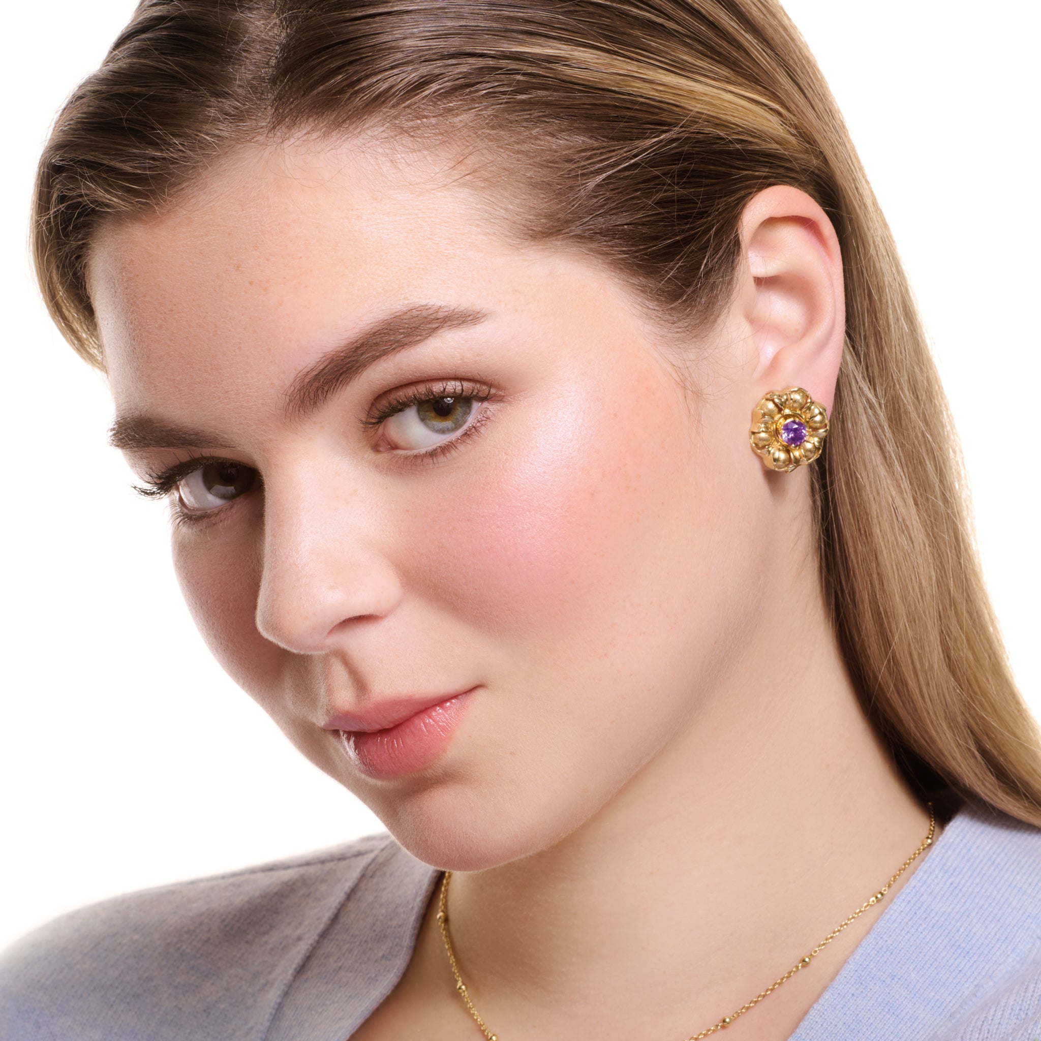 Model wearing handcrafted yellow gold earring halos featuring beads wrapped in leaves.