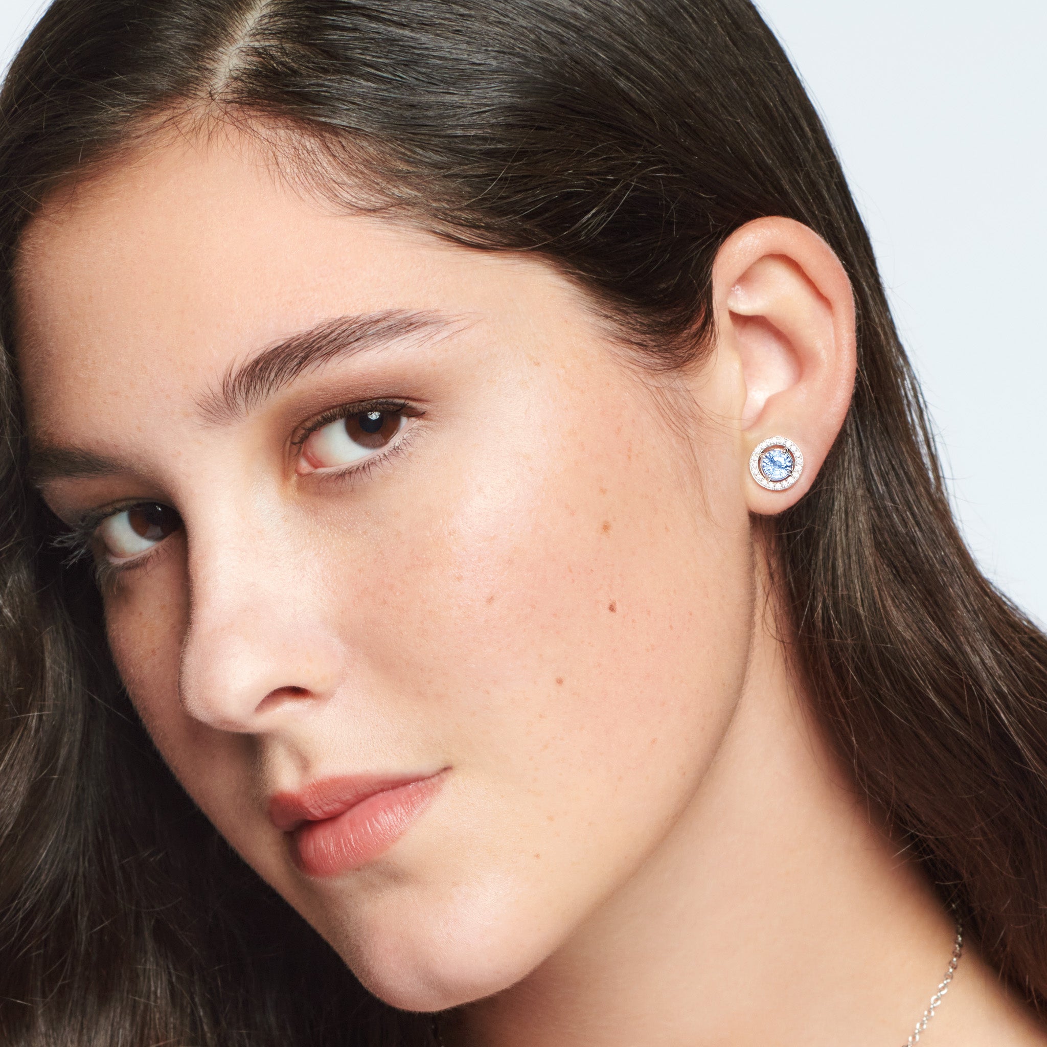 Model wearing handcrafted 18ct white gold earring halos featuring a circular shape with diamonds.