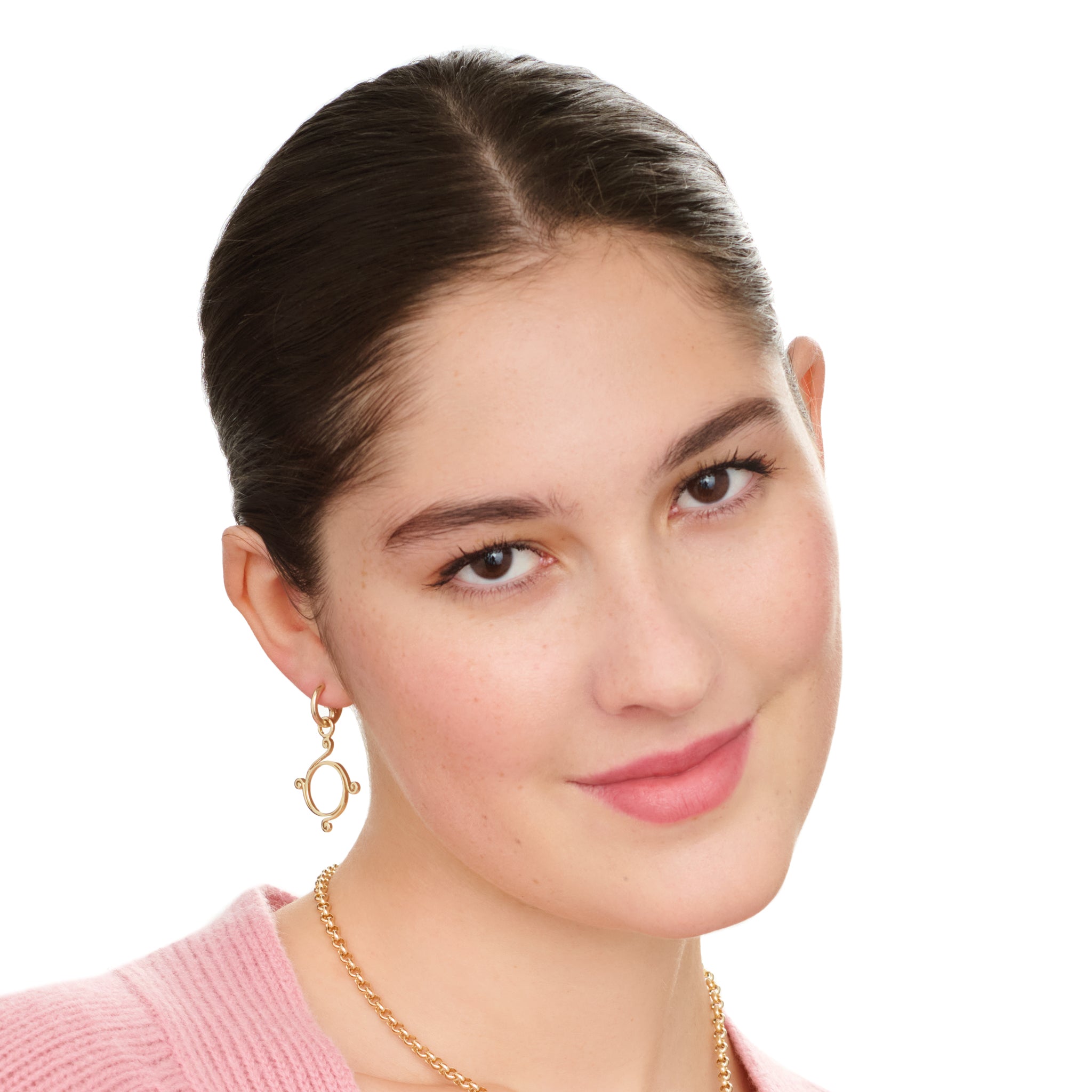 Model wearing handcrafted 9ct yellow gold earring drops with a circular shape and spiral at four points, hanging on gold hoop earrings.