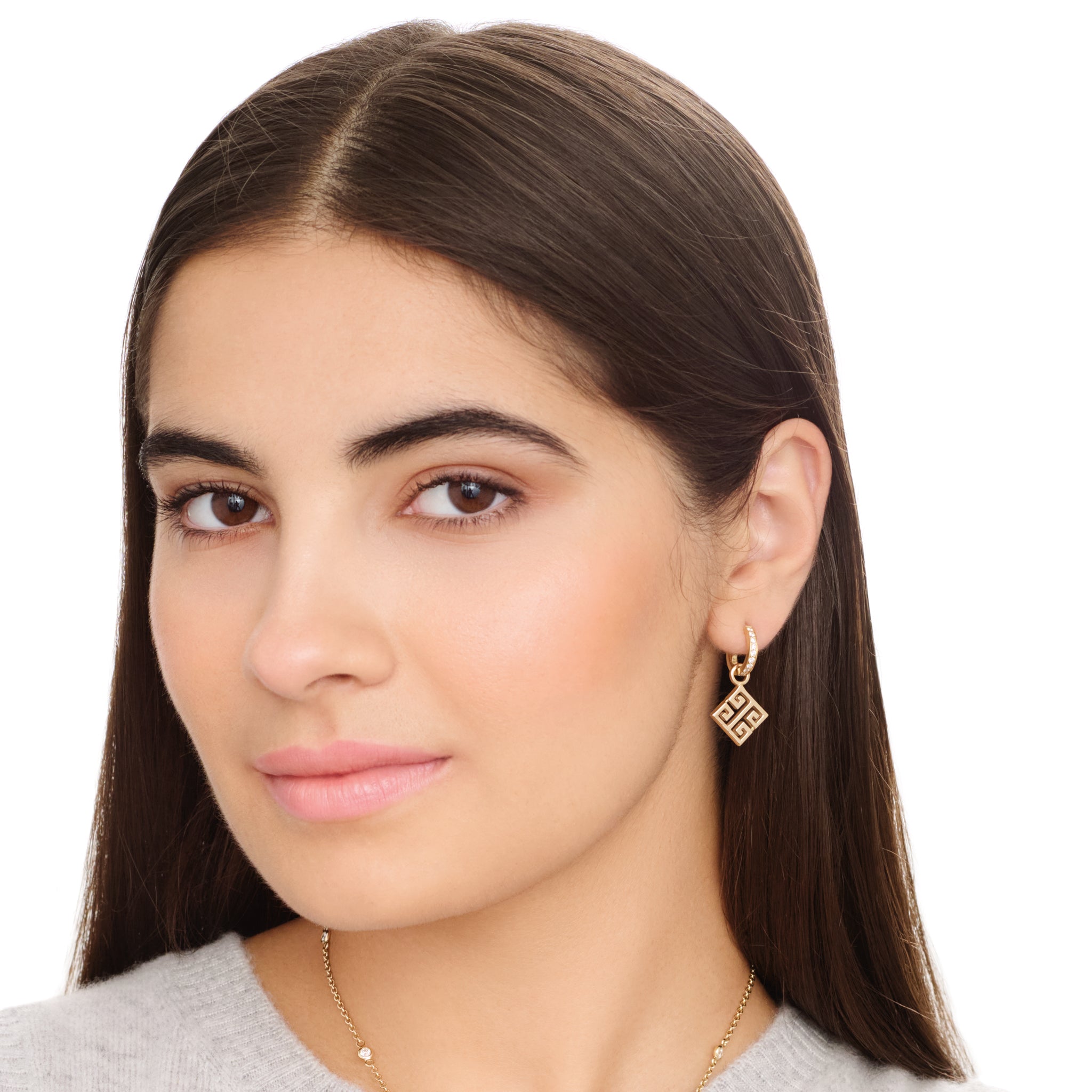 Model wearing handcrafted 9ct yellow gold square earring drops with iconic symmetrical Greek motif, hanging from hoop earring.
