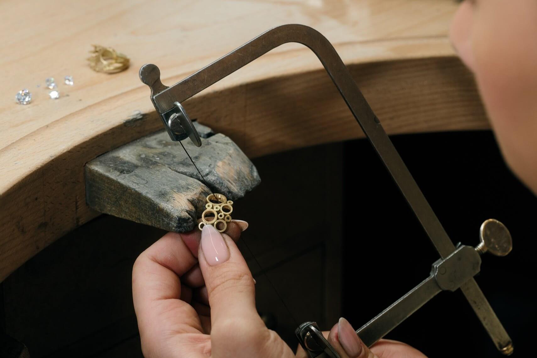Artisan working on an handcrafted 18ct yellow gold ring in London workshop.