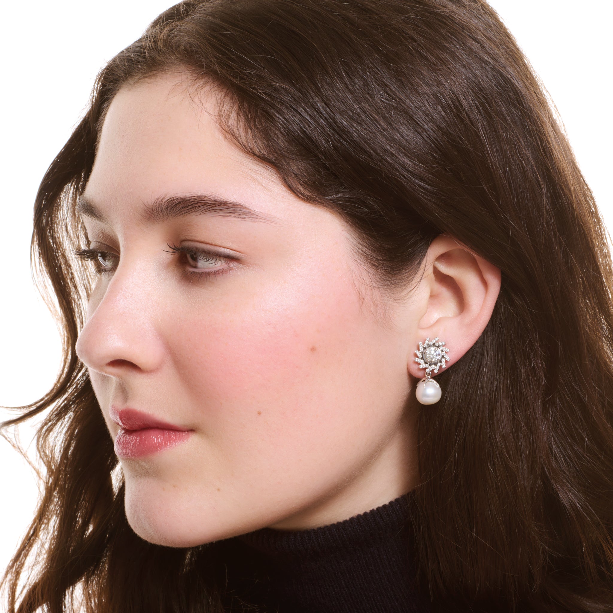 Model wearing handcrafted white gold earring halos featuring a circular shape of diagonal lines with diamonds.