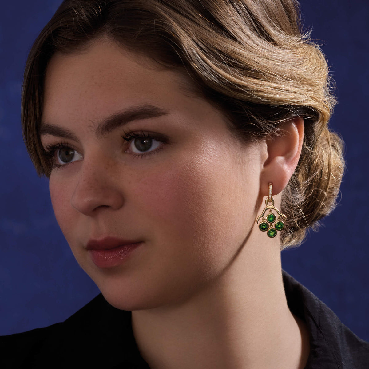 A model wears the Acai earring drops with four chrome diopside facetted drops. A Cassandra Goad design also worn by Catherine, Princess of Wales.