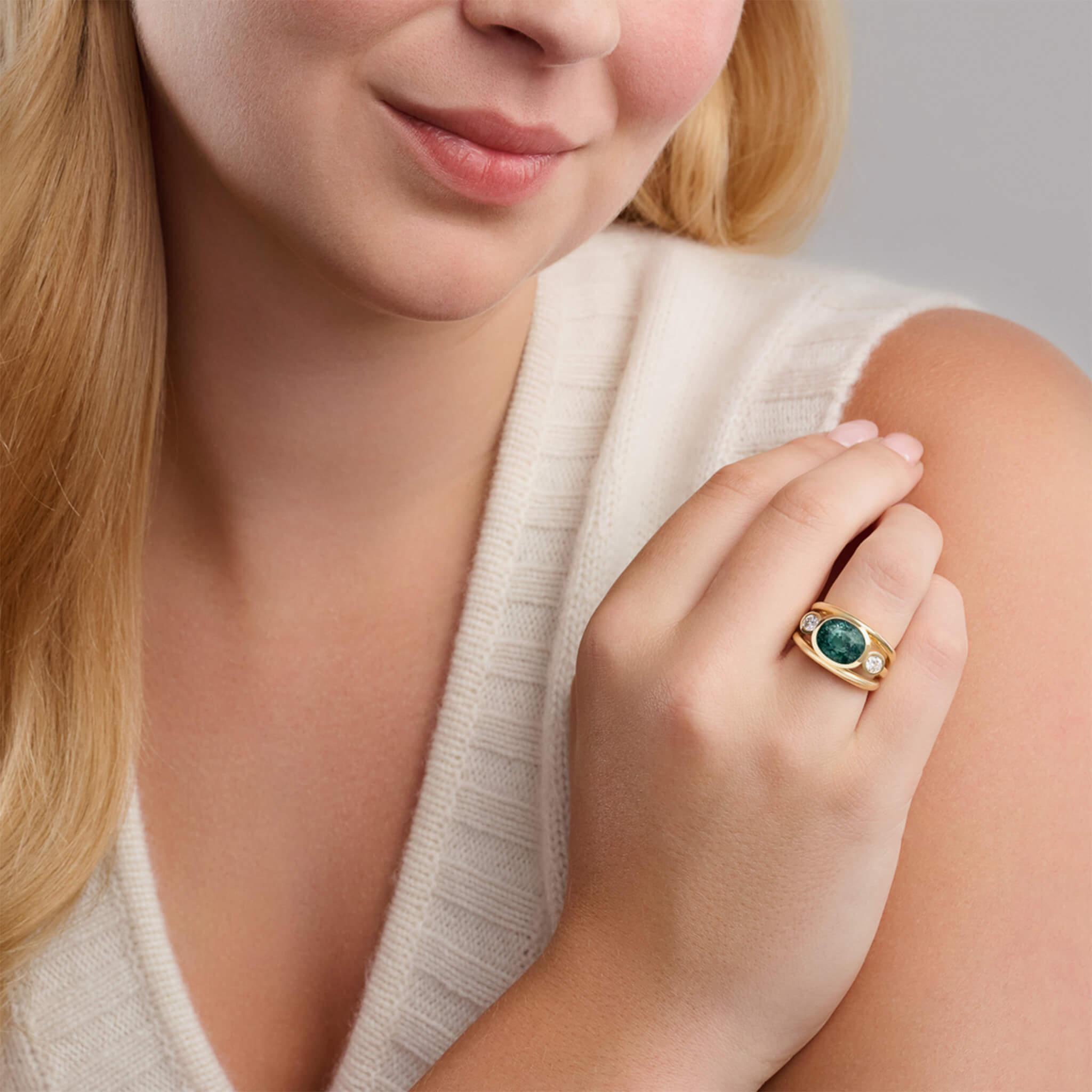 Handcrafted 18ct yellow gold ring with a central green sapphire, the birthstone of September, flanked by two round diamonds.