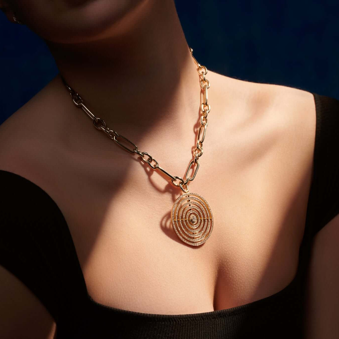 Model wearing a handcrafted 18ct yellow gold necklace pendant featuring five circles of gold with diamonds.