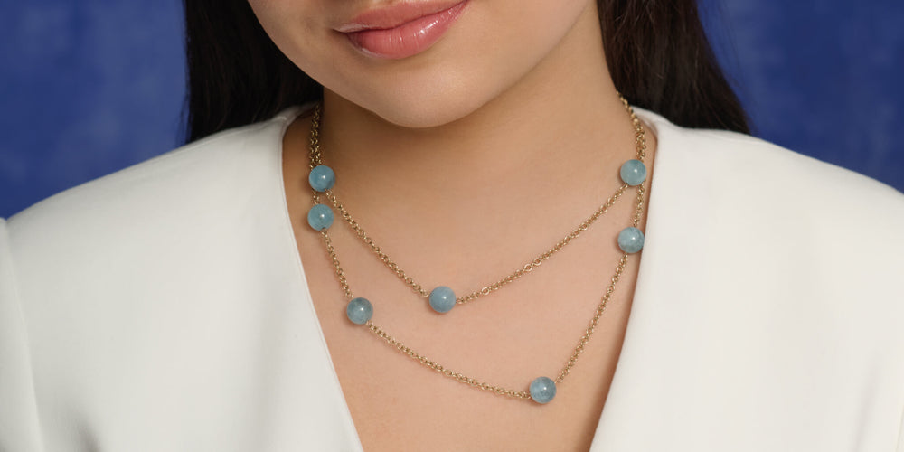 Model wearing a folded aquamarine bead necklace for a layered look
