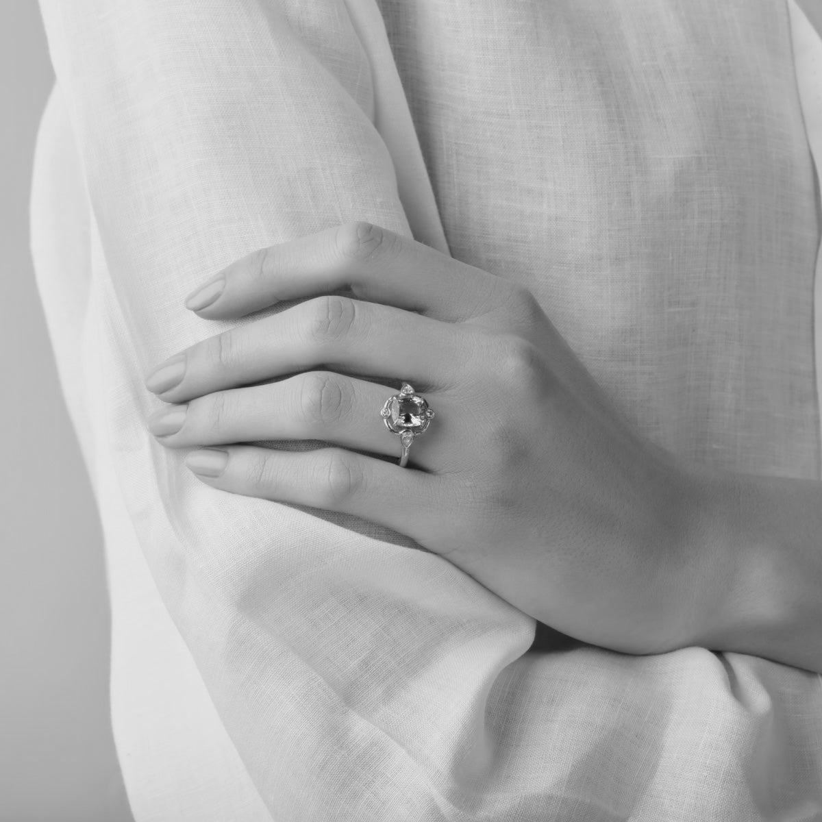 An engagement ring with a central gemstone, complemented by diamonds set on each side of the band.