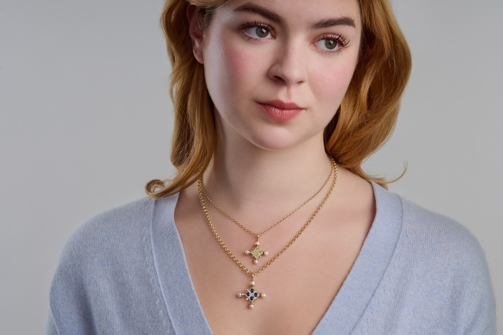 Model wearing Madrid crosses with different facetted gemstones for different birthstones