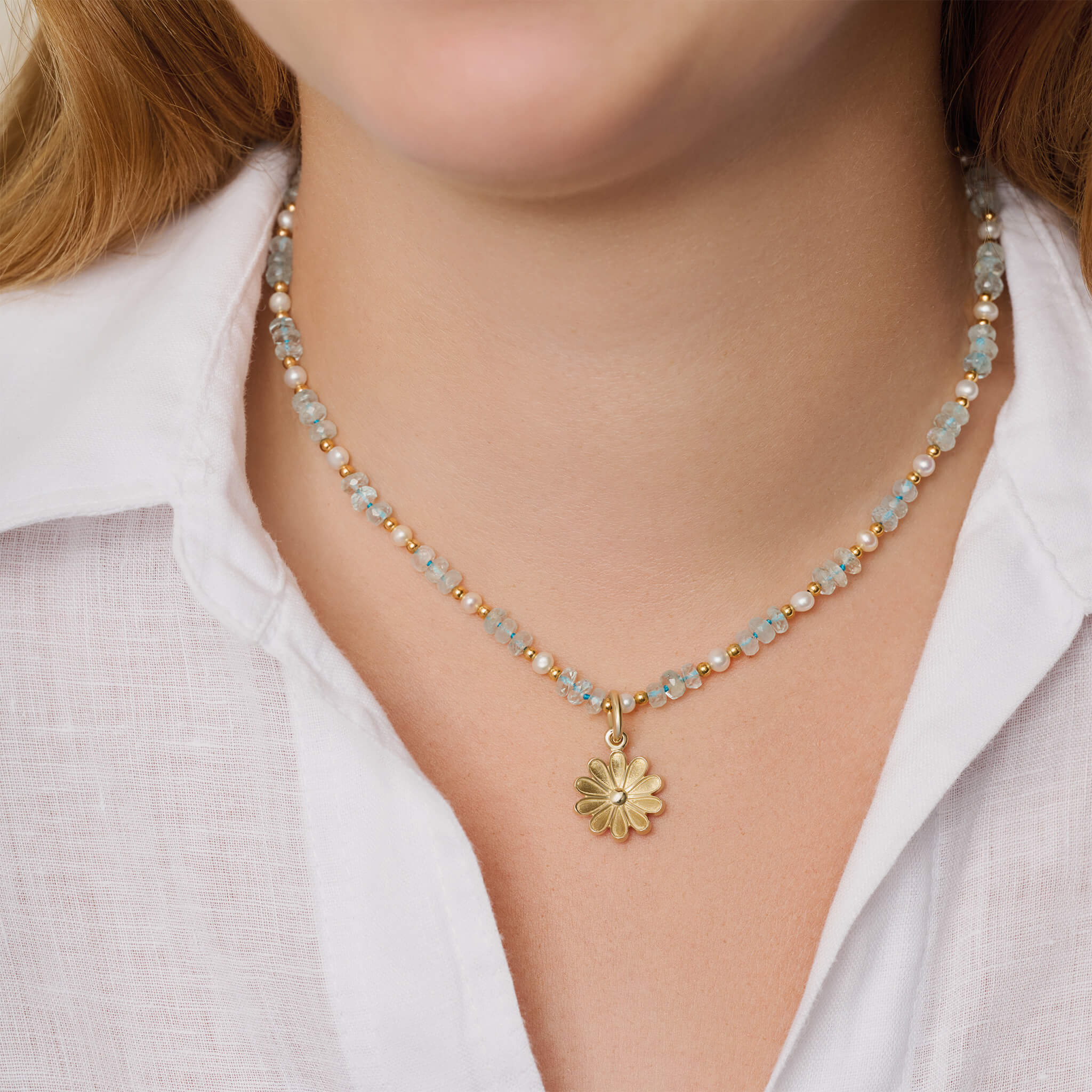 Model wearing handcrafted 9ct yellow gold necklace pendant of an anemone flower, in full bloom collection