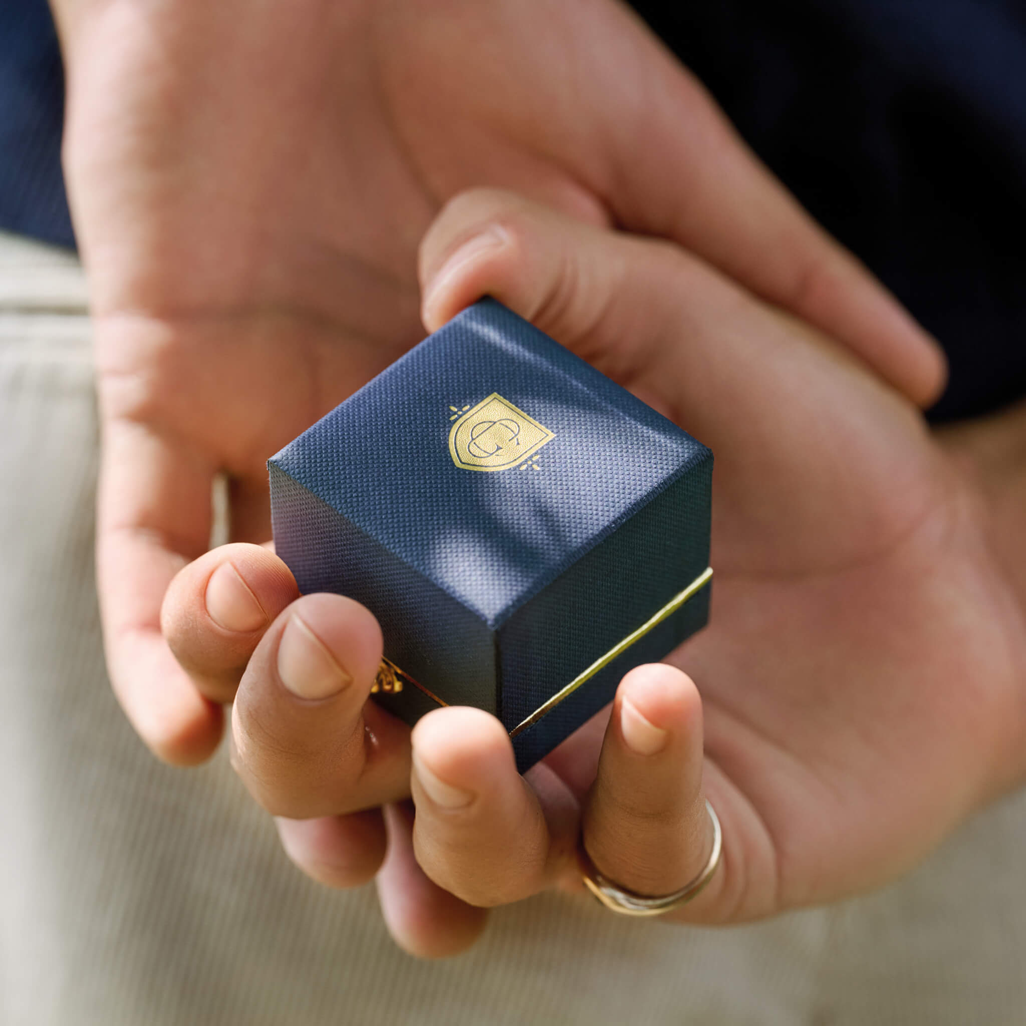 man holding cassandra goad engagement ring box