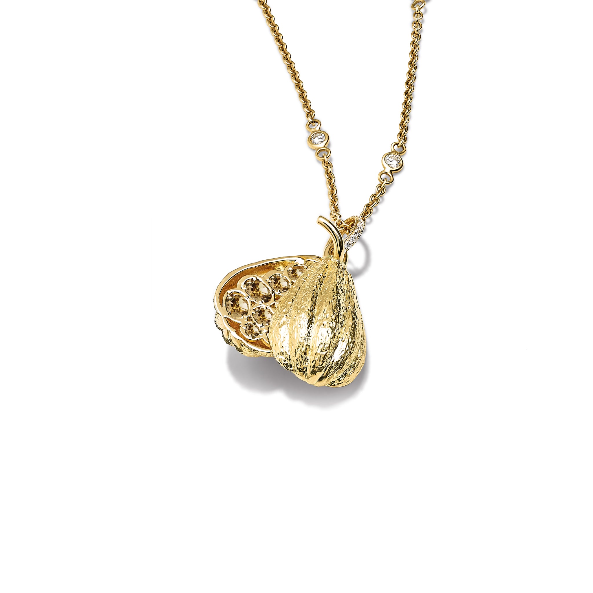 Handcrafted 9ct yellow gold necklace pendant in the shape of a cocoa pod which swivels open to reveal rose cut smoky quartz with a diamond pave loop.