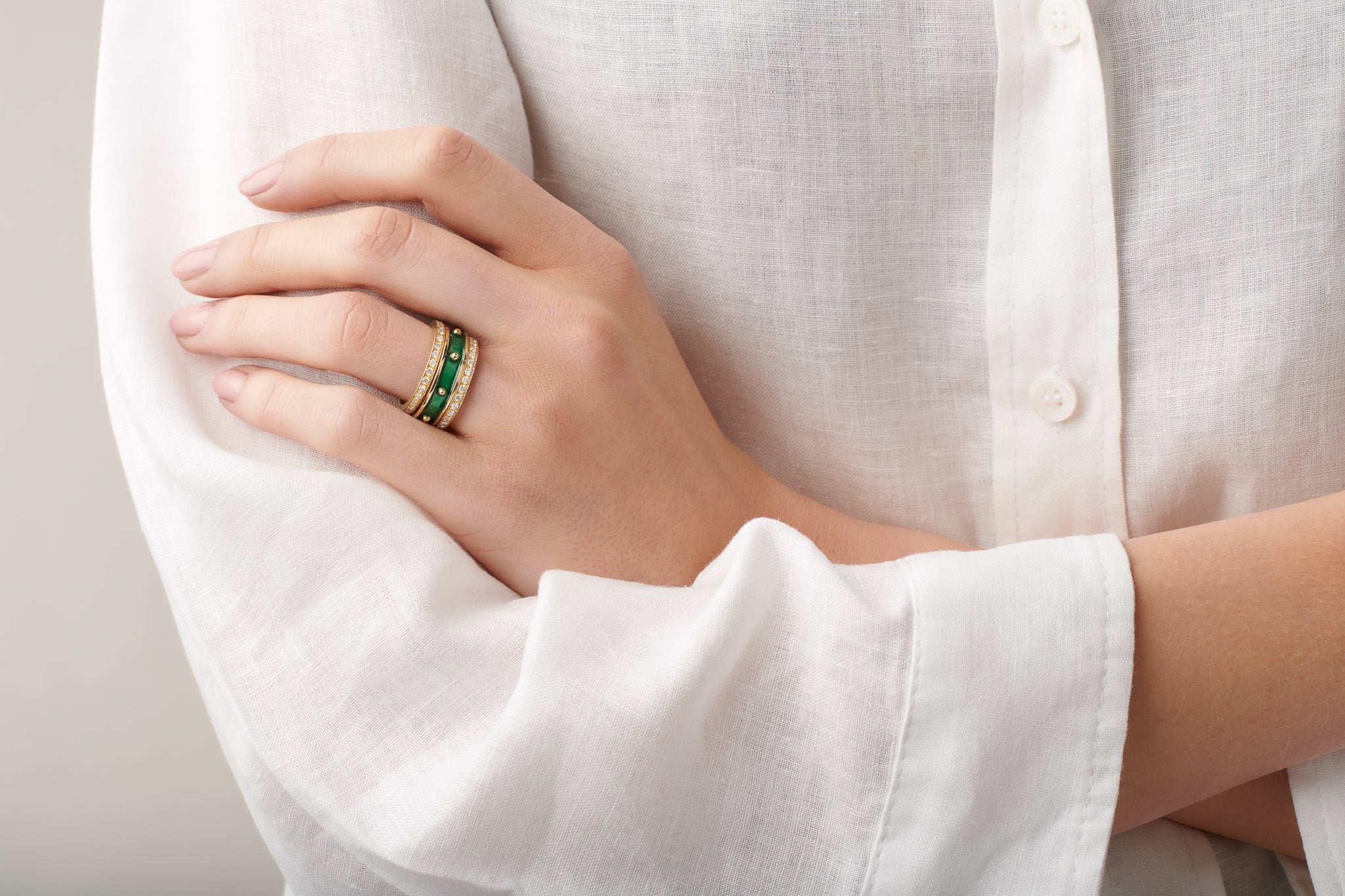 Model wearing handcrafted yellow gold eternity rings featuring diamonds.