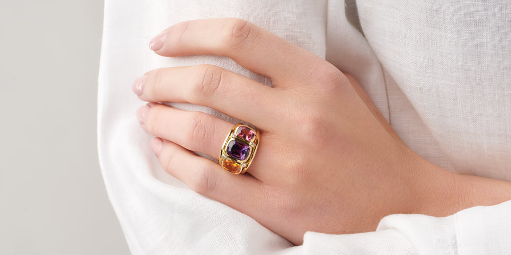 Model wearing a handcrafted yellow gold ring featuring a facetted tourmaline, birthstone of October.