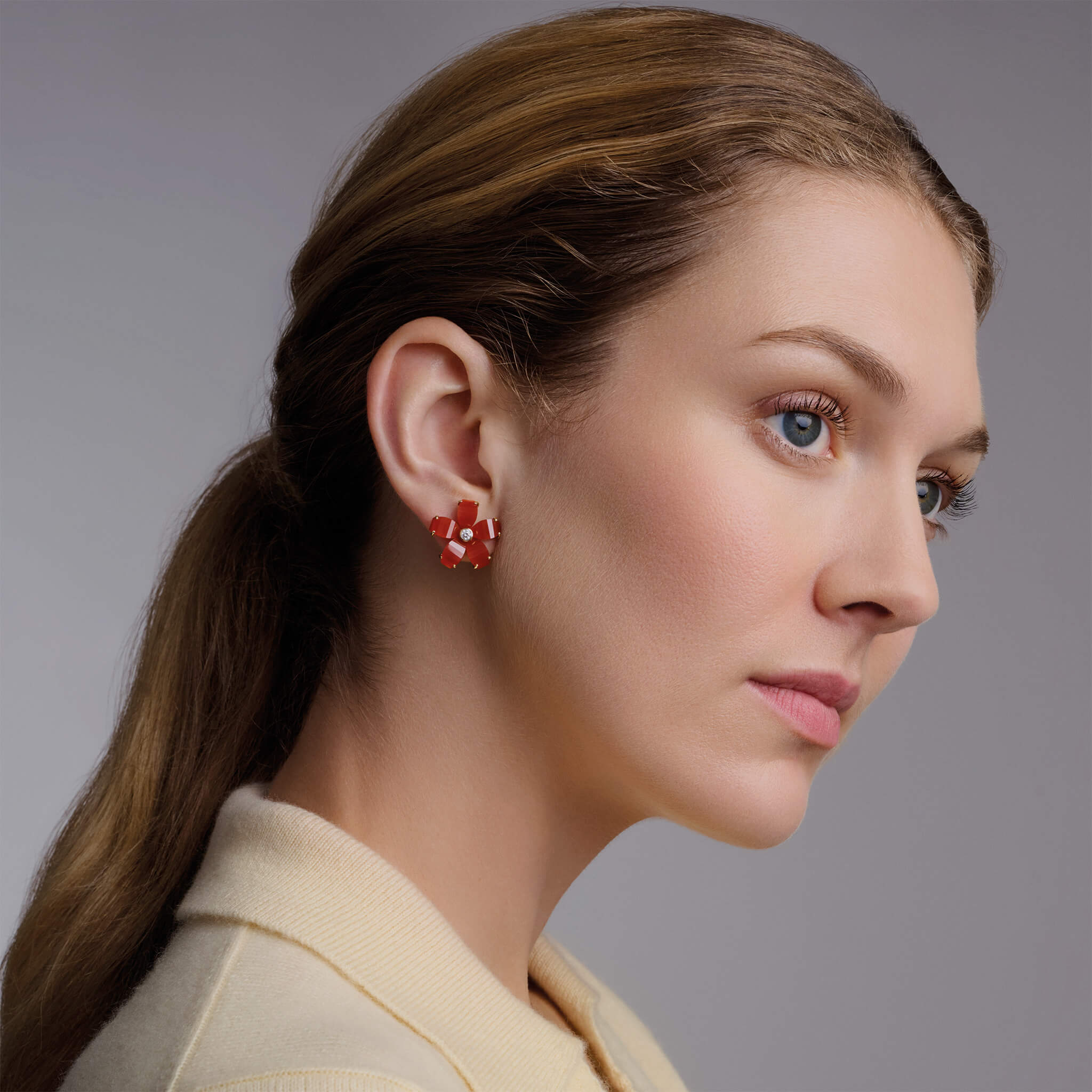 Model wearing Cassandra Goad Frangipani earrings with cornelian and diamond.