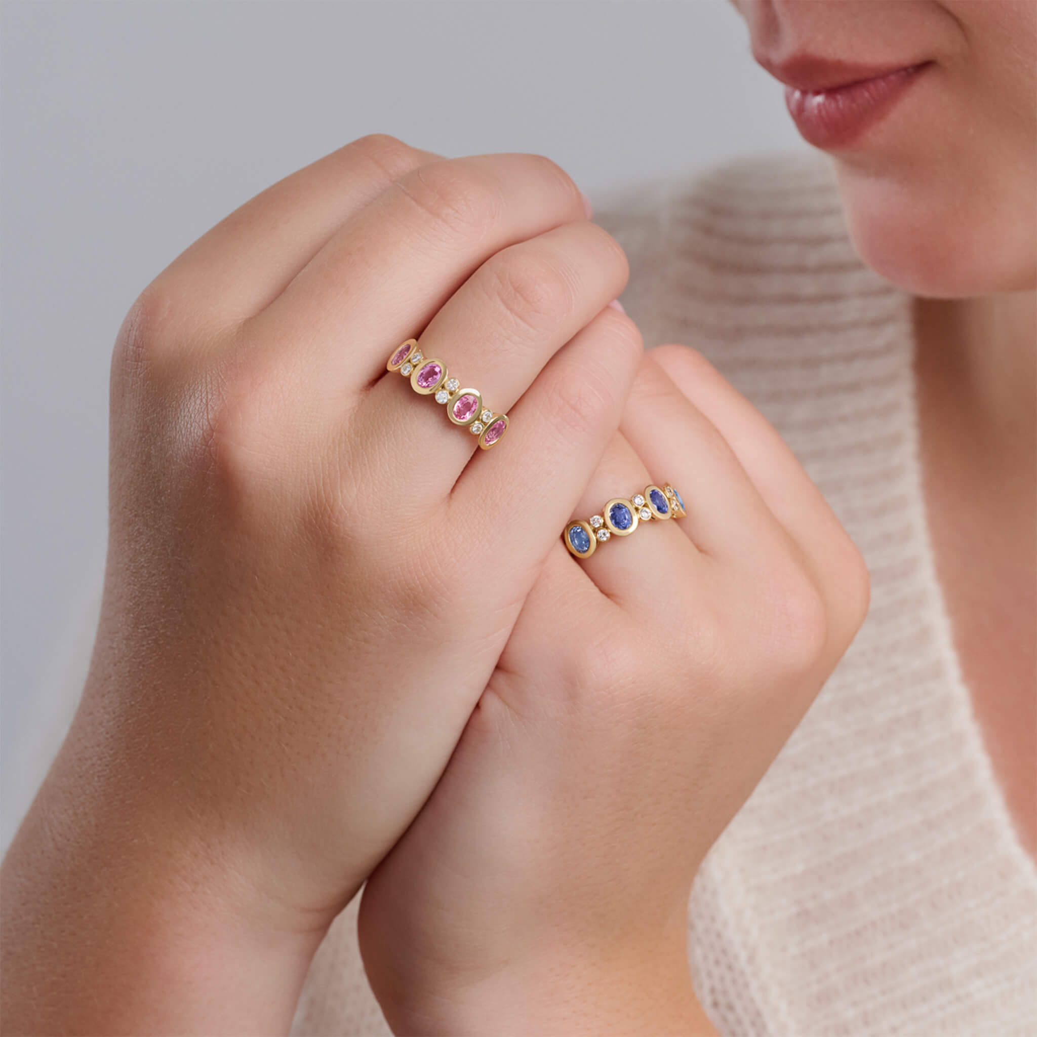 Model wearing handcrafted Imara eternity rings with pink sapphire and blue sapphire, September birthstone