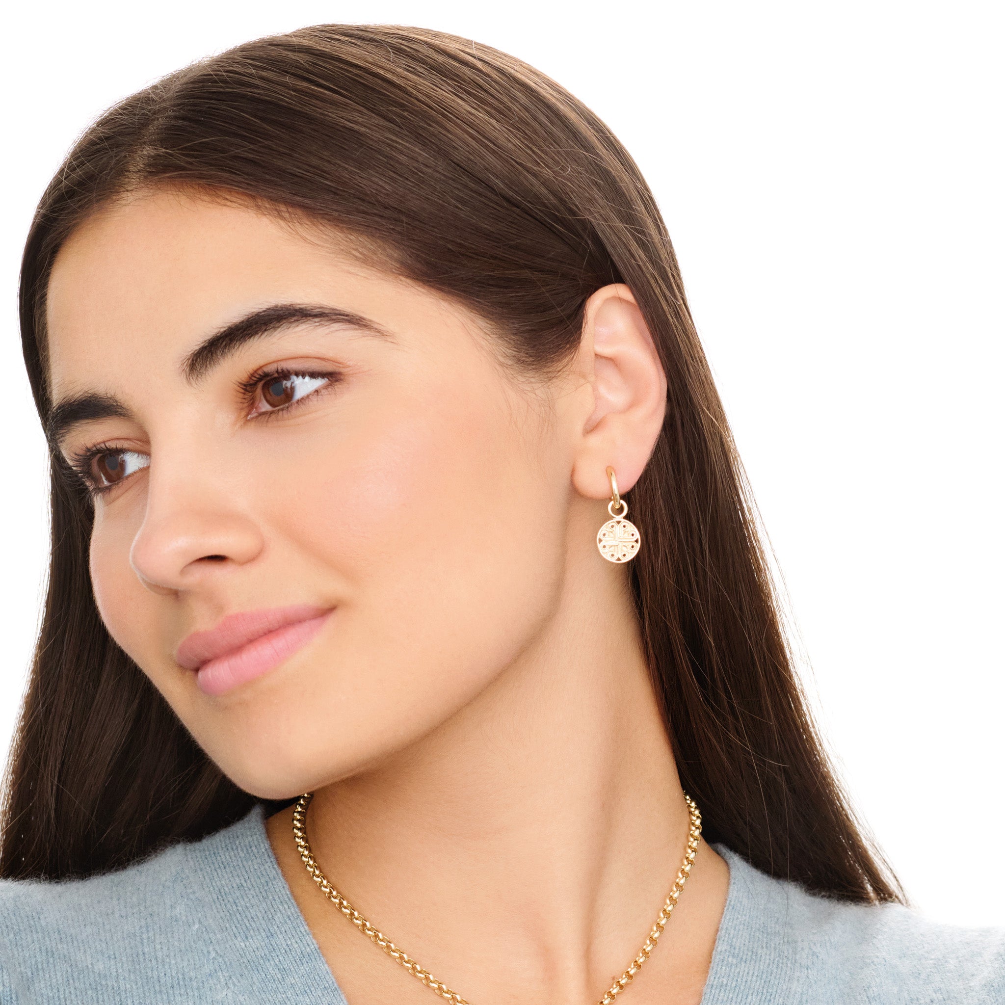 Model wears handcrafted interchangeable silver circular earring drops with a cross-like motif in the centre.