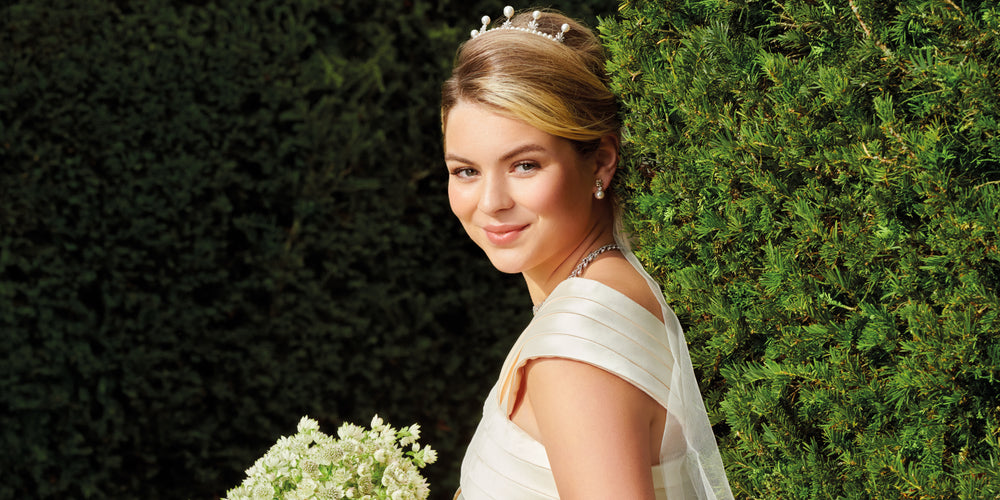 Model dressed as a bride holding a bouquet of flowers wearing bridal jewellery
