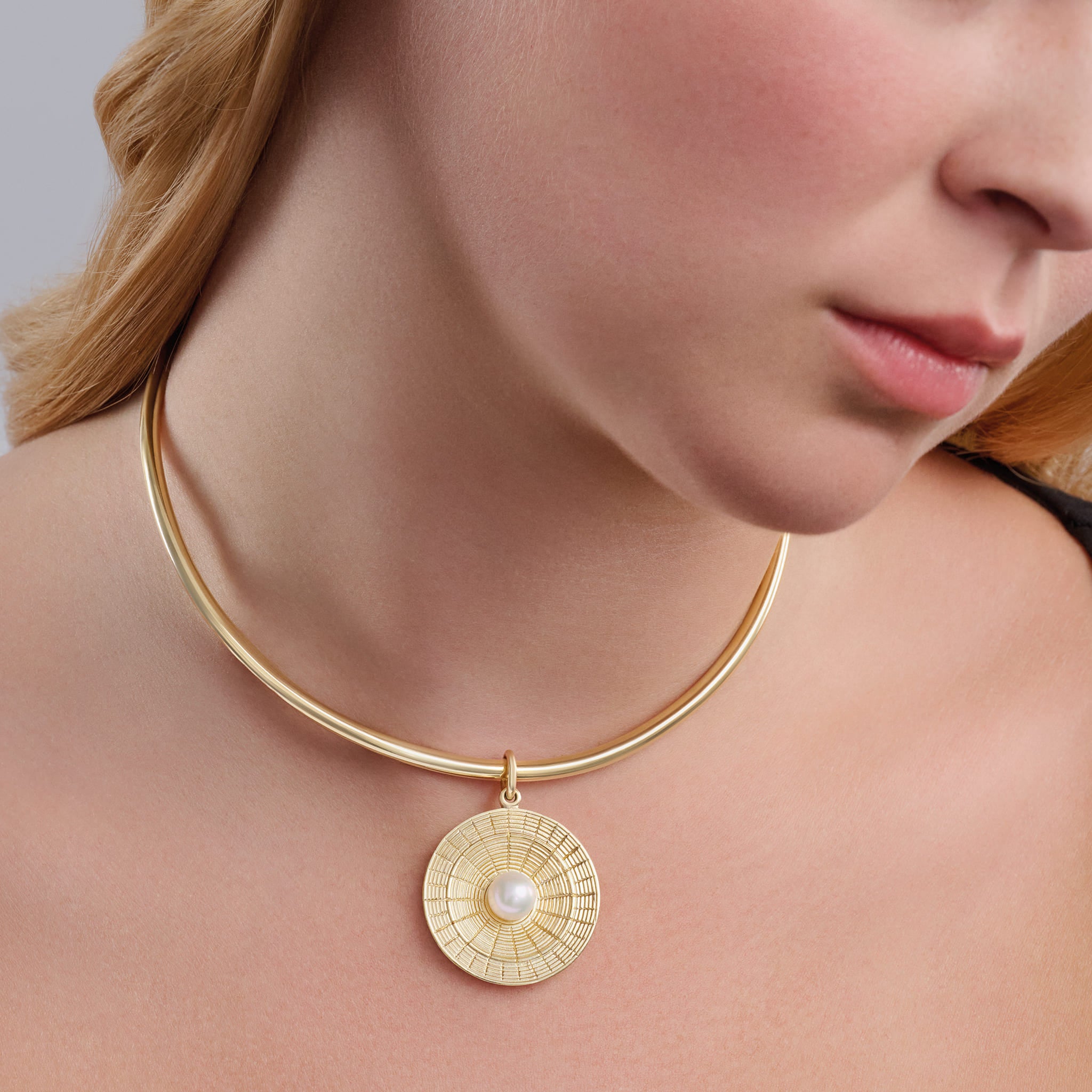 Model wears handcrafted Epidavros necklace pendant in precious metal with pearl, inspired by the ancient Greek amphitheatre of Epidaurus, june birthstone