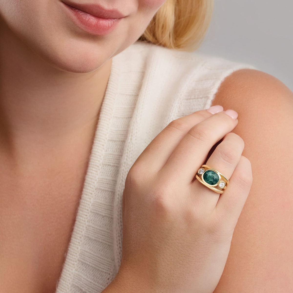 Model wears handcrafted 18ct yellow gold Aeneus Roman ring with green sapphire and brilliant round cut diamond. September birthstone.