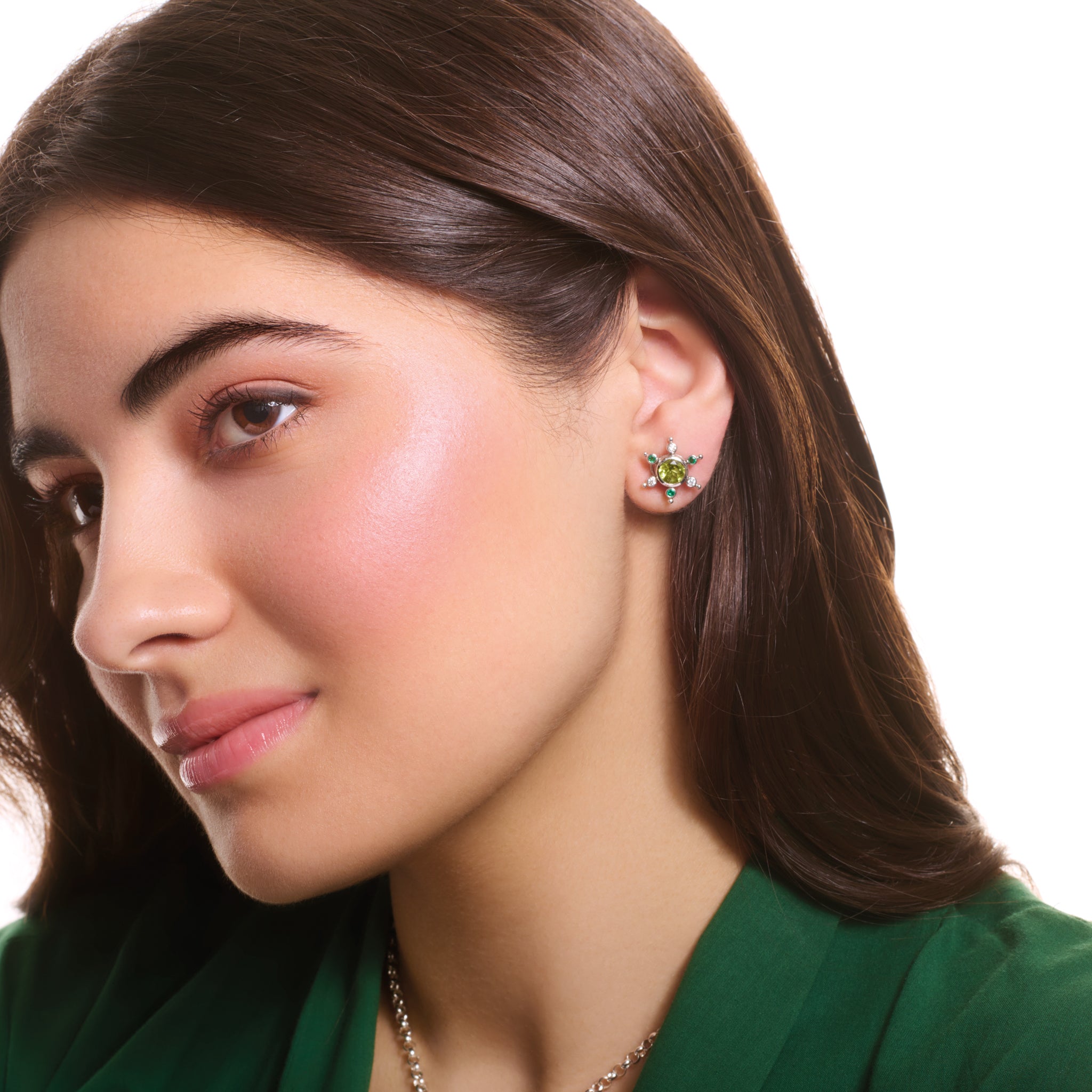 Model wears handcrafted white gold earring halos inspired by a cactus, featuring six prongs, set small emerald and diamond.