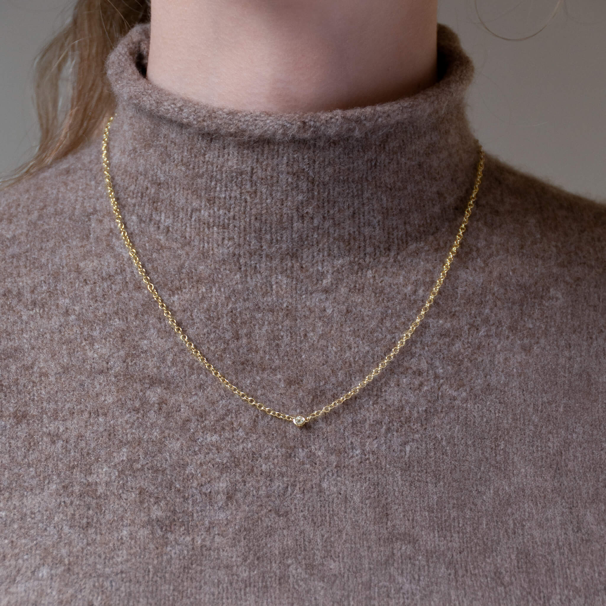 Handcrafted yellow gold necklace with a single small diamond on an adjustable chain, april birthstone