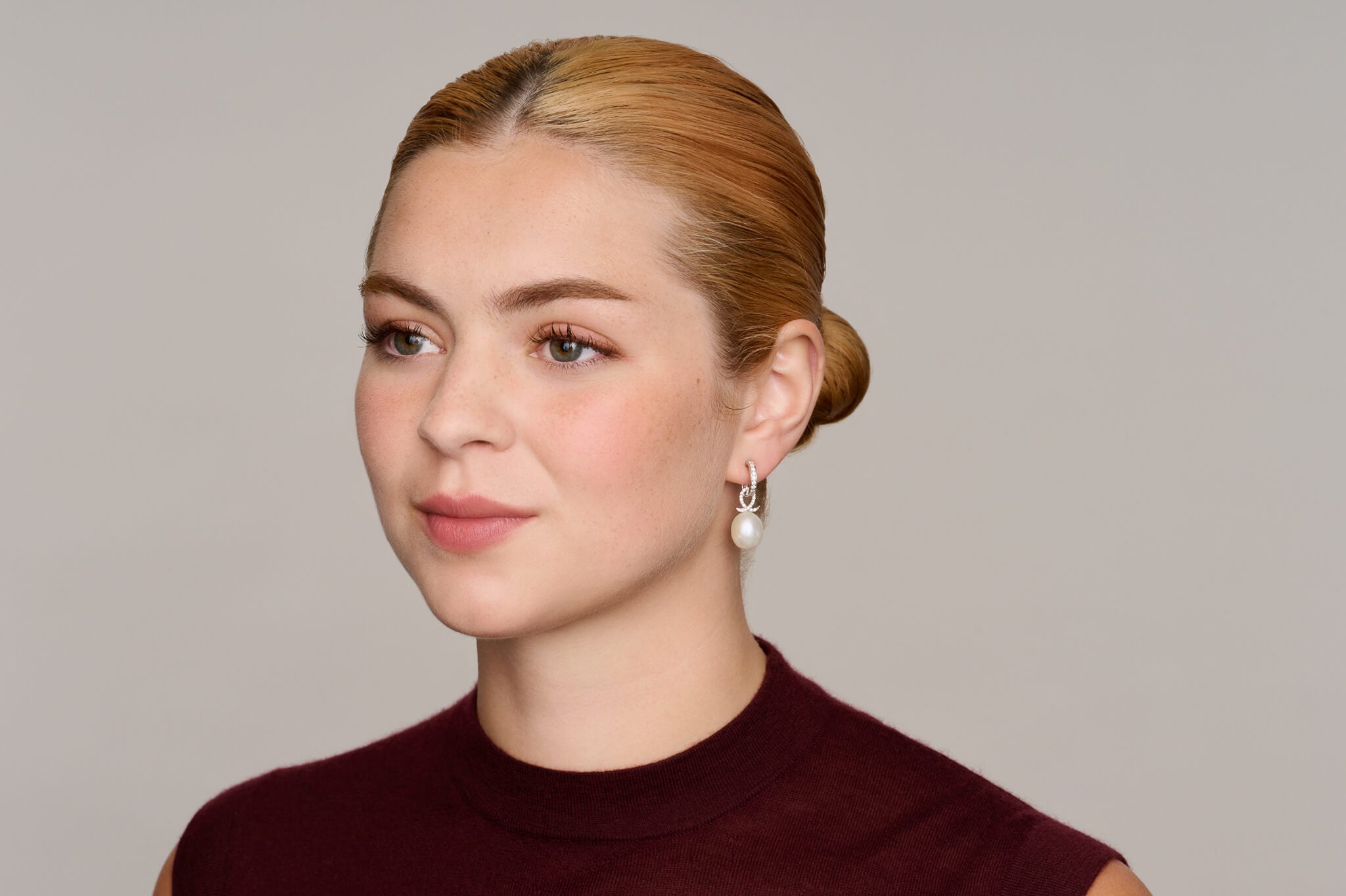 Model wears earrings drop off an Astrea hoop earring showcasing our interchangeable earring drops.