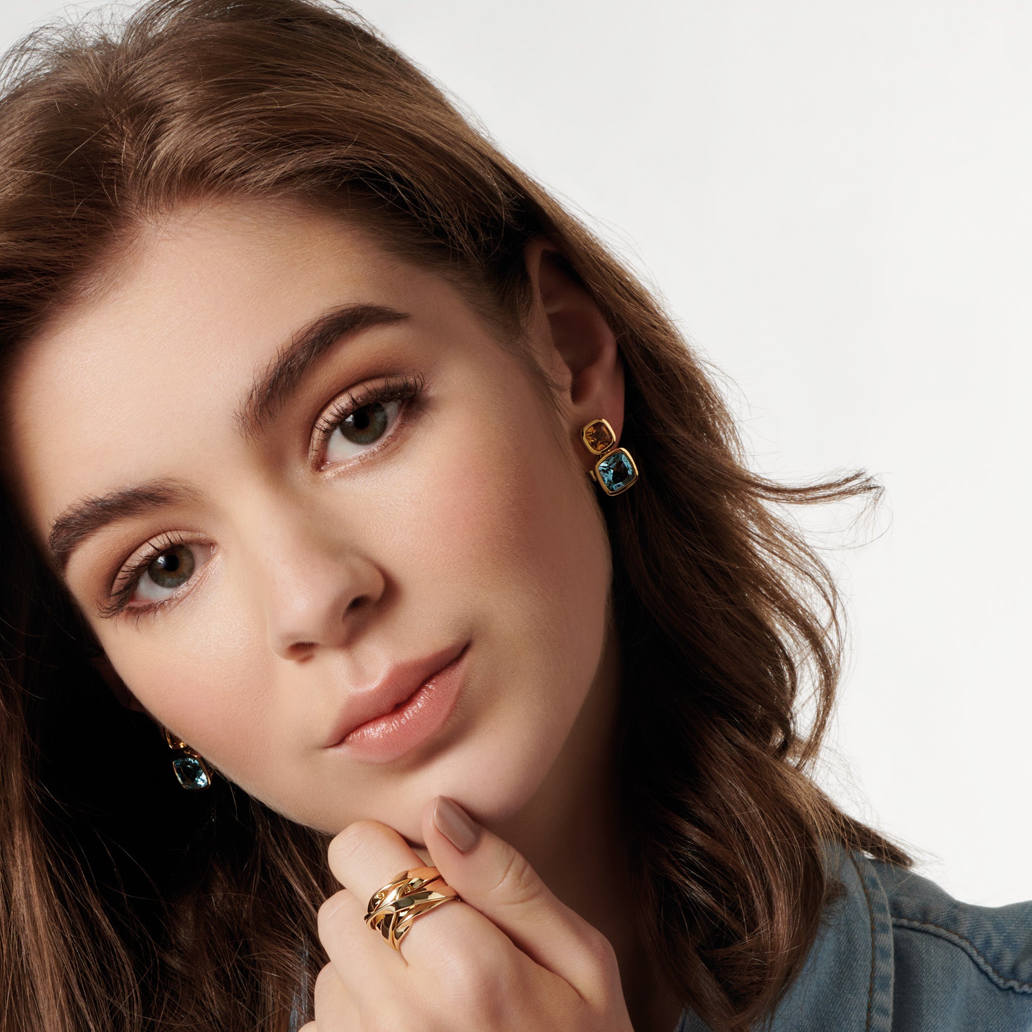 Model wearing handcrafted 18ct yellow gold square shaped earrings featuring citrine and blue topaz gemstones, november birthstones