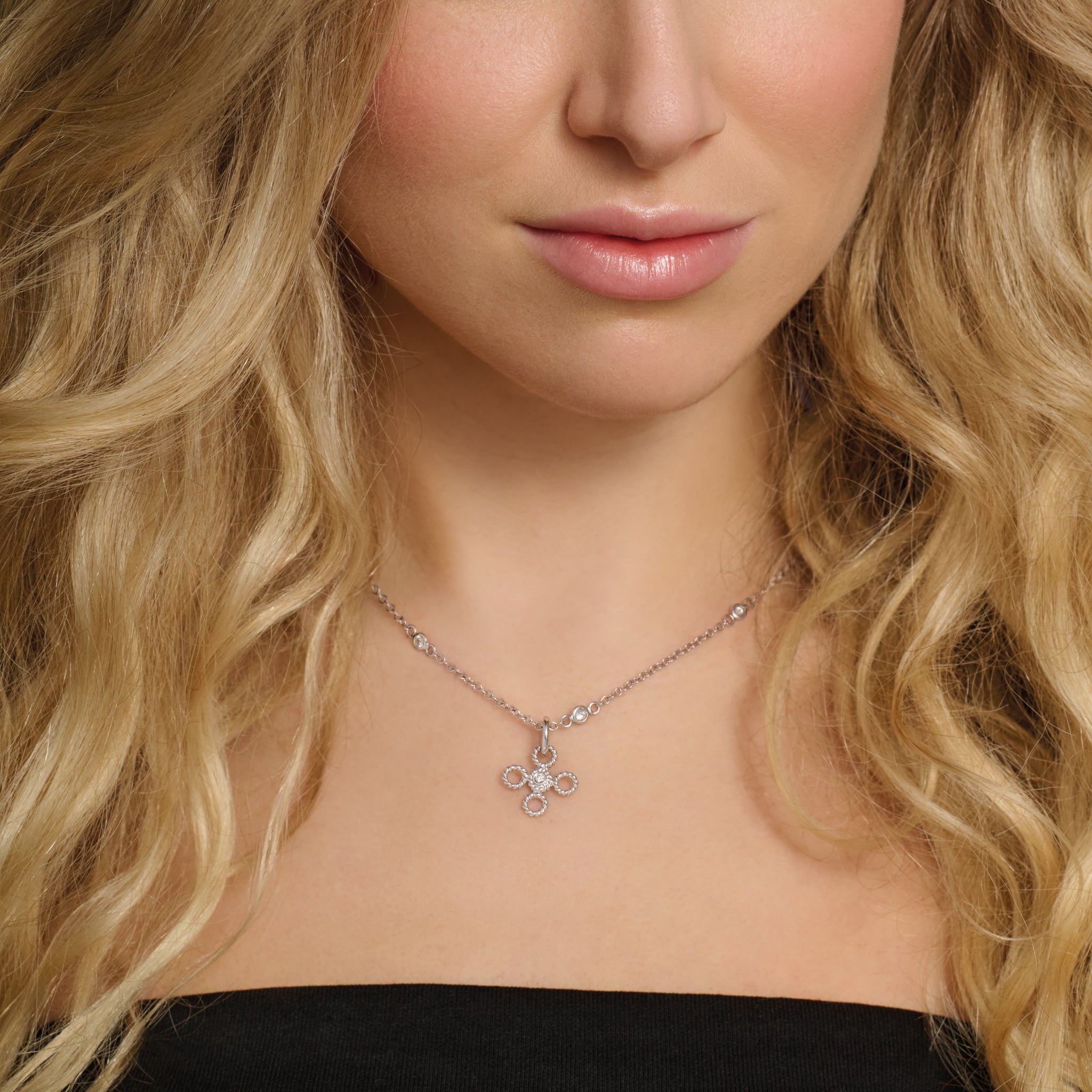 Model wears handcrafted white gold necklace pendant featuring a textured rope-like shape with a diamond.