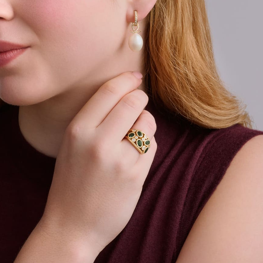 Model wears handcrafted 18ct yellow gold ring featuring four green zircons and smaller diamonds.