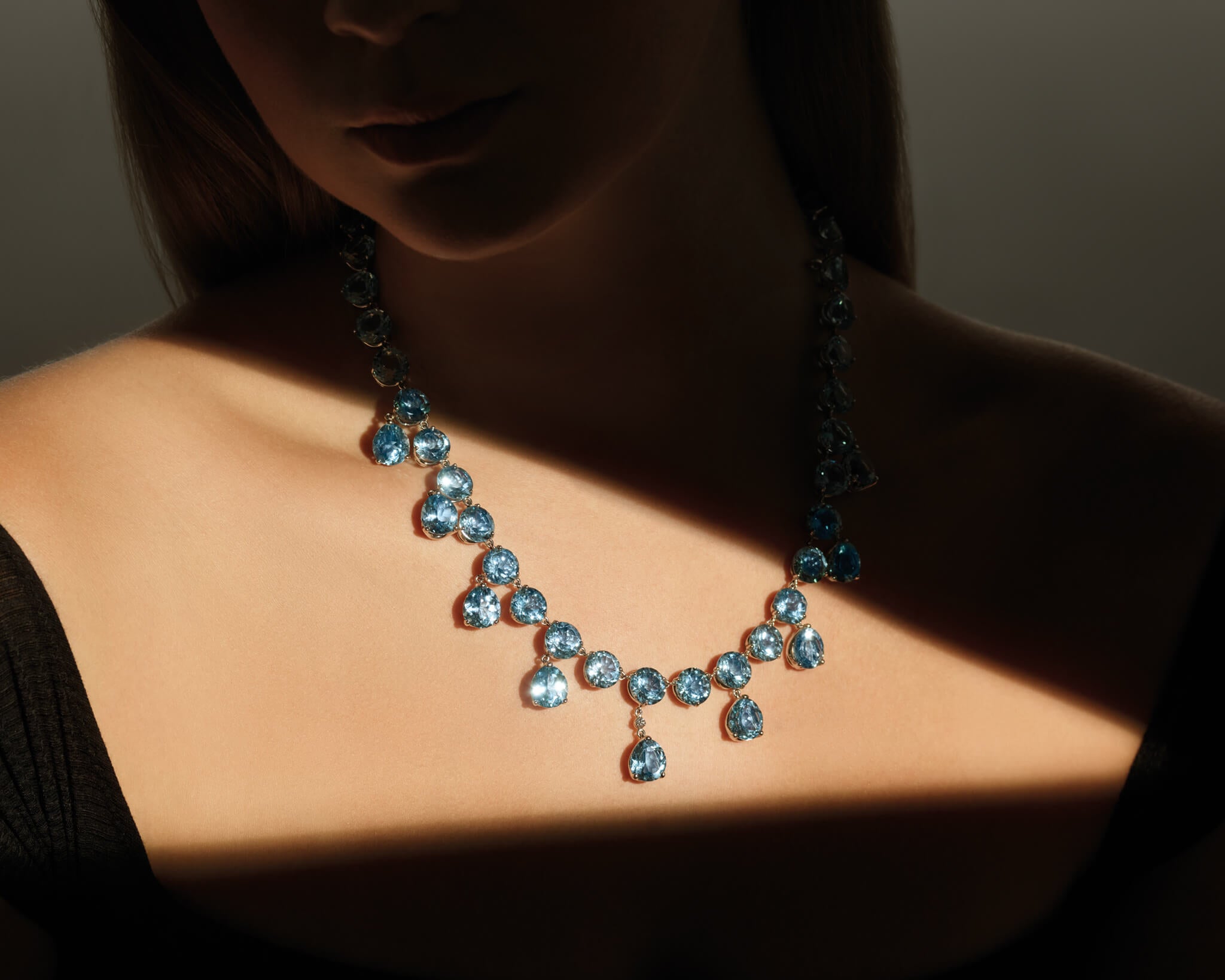 Model wears Rivière Poires necklace in white gold with blue topaz and diamond