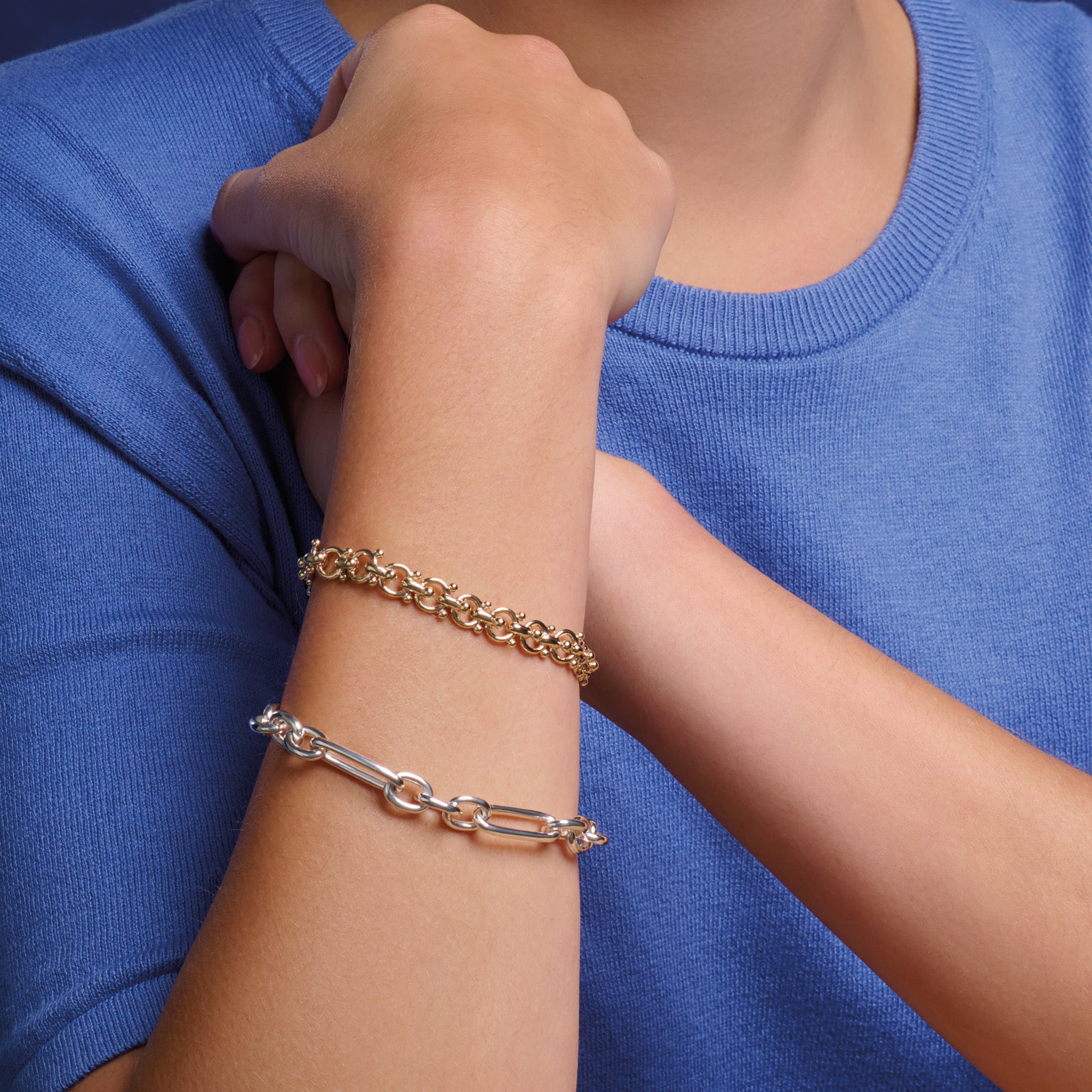 Model wearing handcrafted silver link bracelet featuring chunky round and rounded rectangular links interconnected.