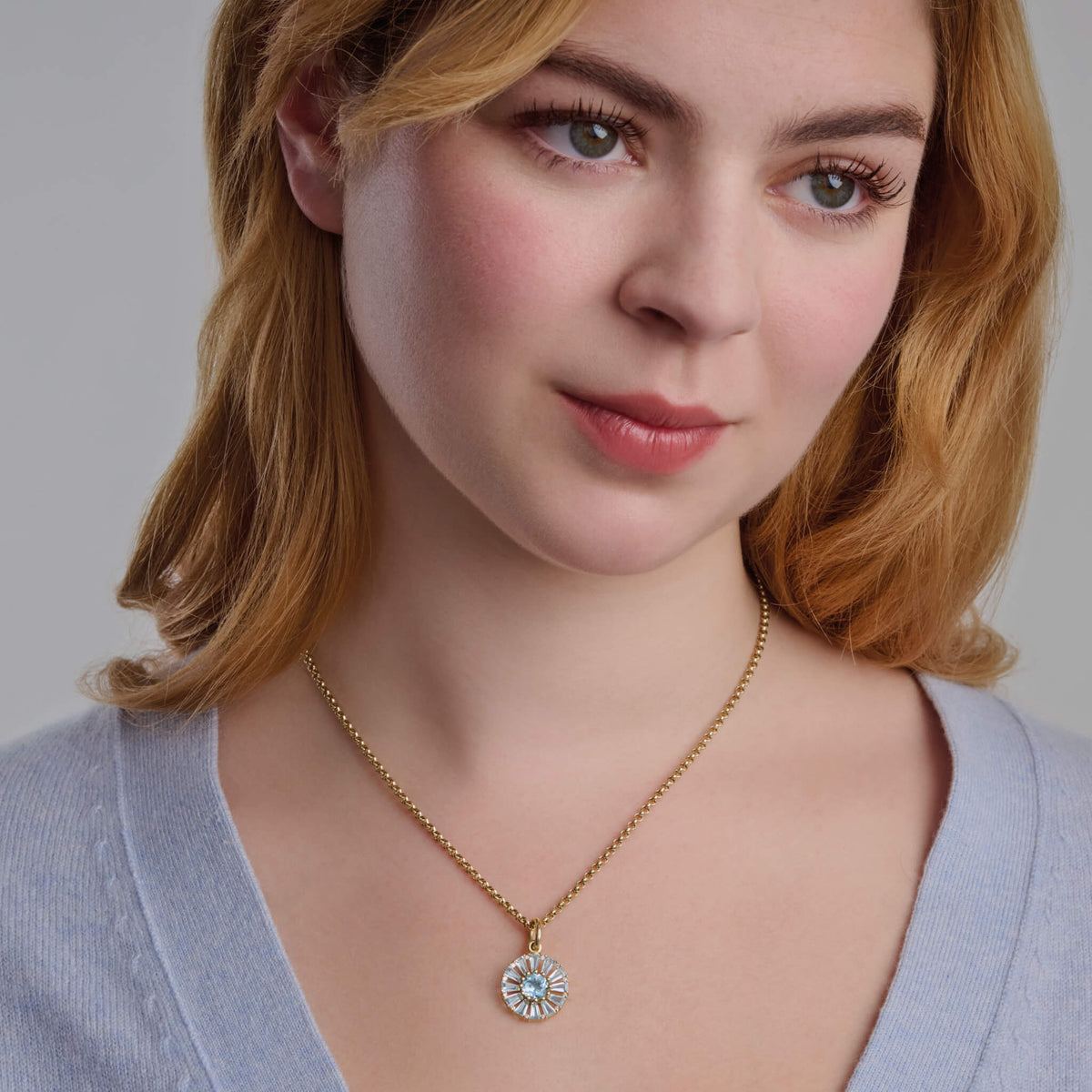 Model wears Roi Soleil small pendant with facetted baguette cut blue topaz and diamond. The birthstone for November.