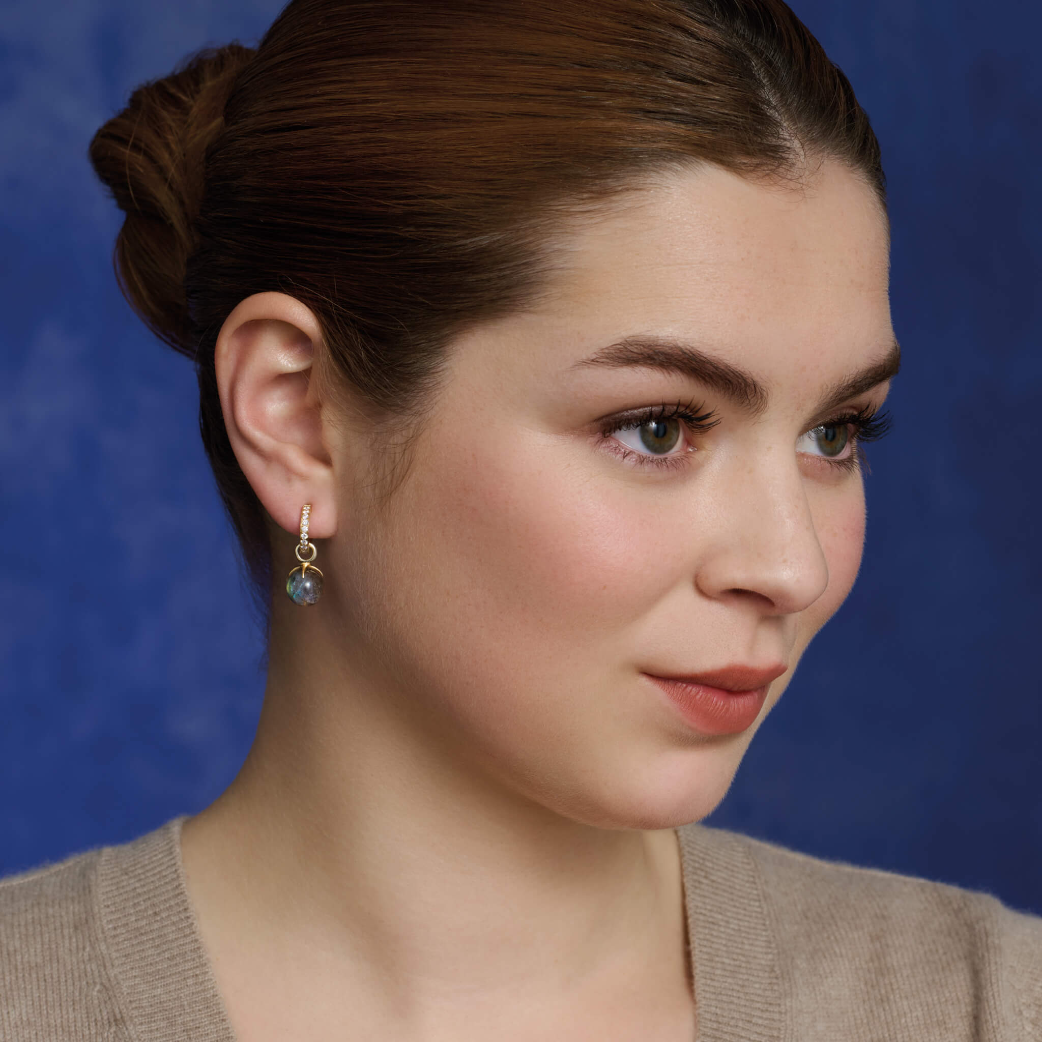 Model wears handcrafted yellow gold earring drops with round labradorite beads.
