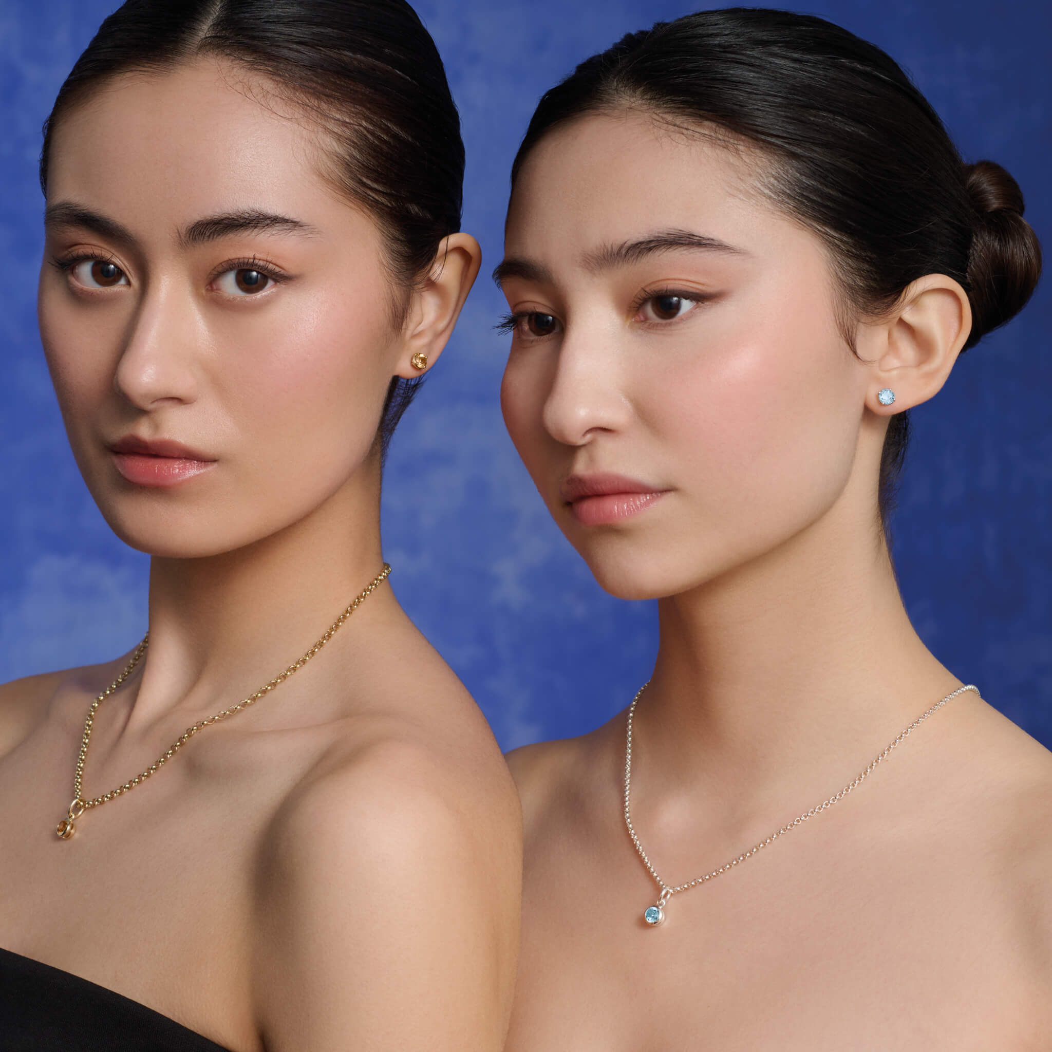 Models wear handcrafted necklace pendants in precious metal featuring a round facetted precious gemstone.
