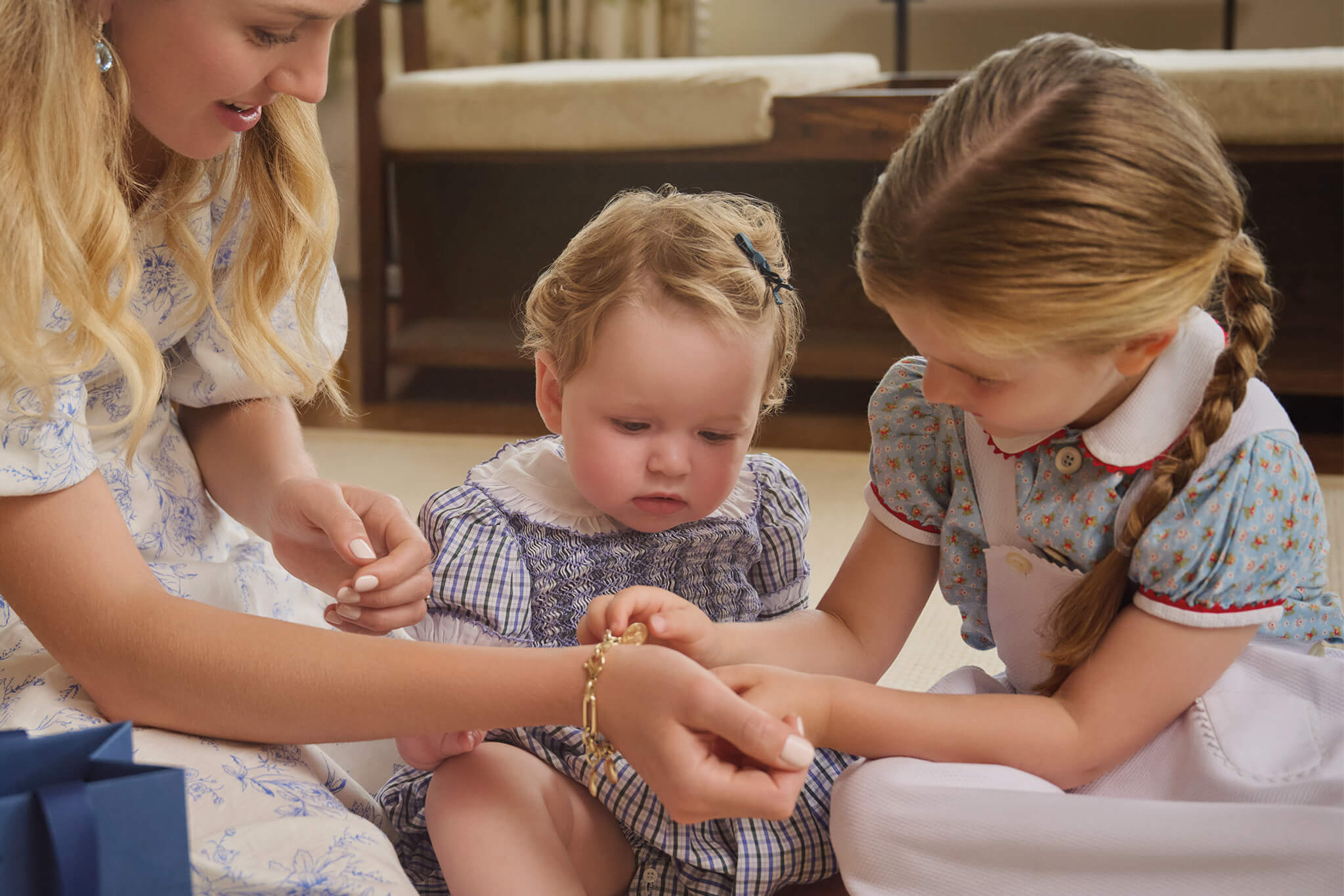 Mother and daughters featuring Cassandra Goad yellow gold charm bracelet