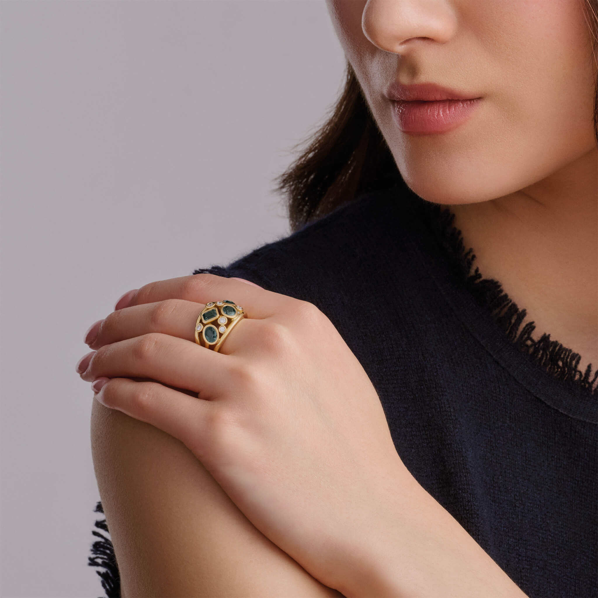 Handcrafted 18ct yellow gold ring featuring four green sapphires and smaller diamonds.