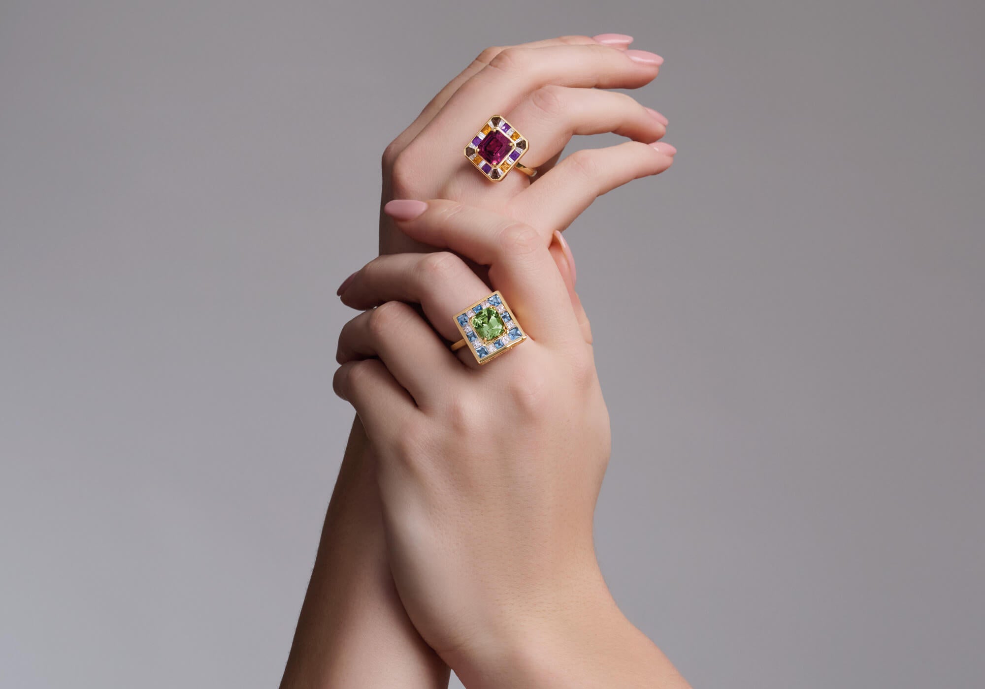 Model wearing place des vosges rings with pink garnet and mint tourmaline as central stone.