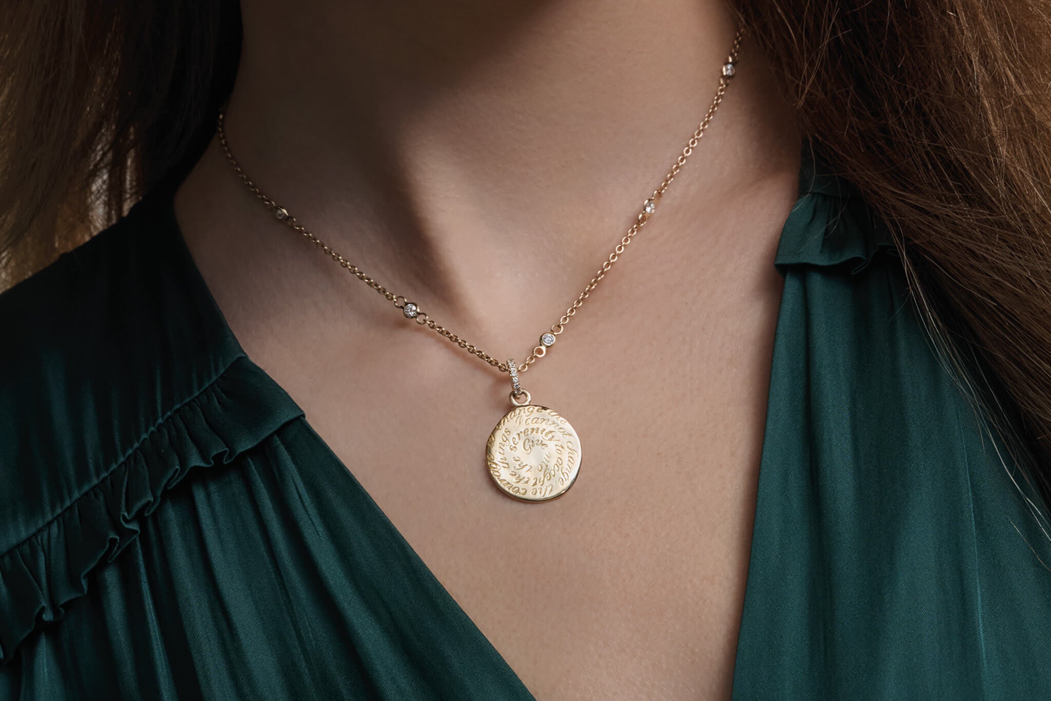 Model wearing handcrafted round gold jewellery featuring pendants engraved with inspirational quotes.