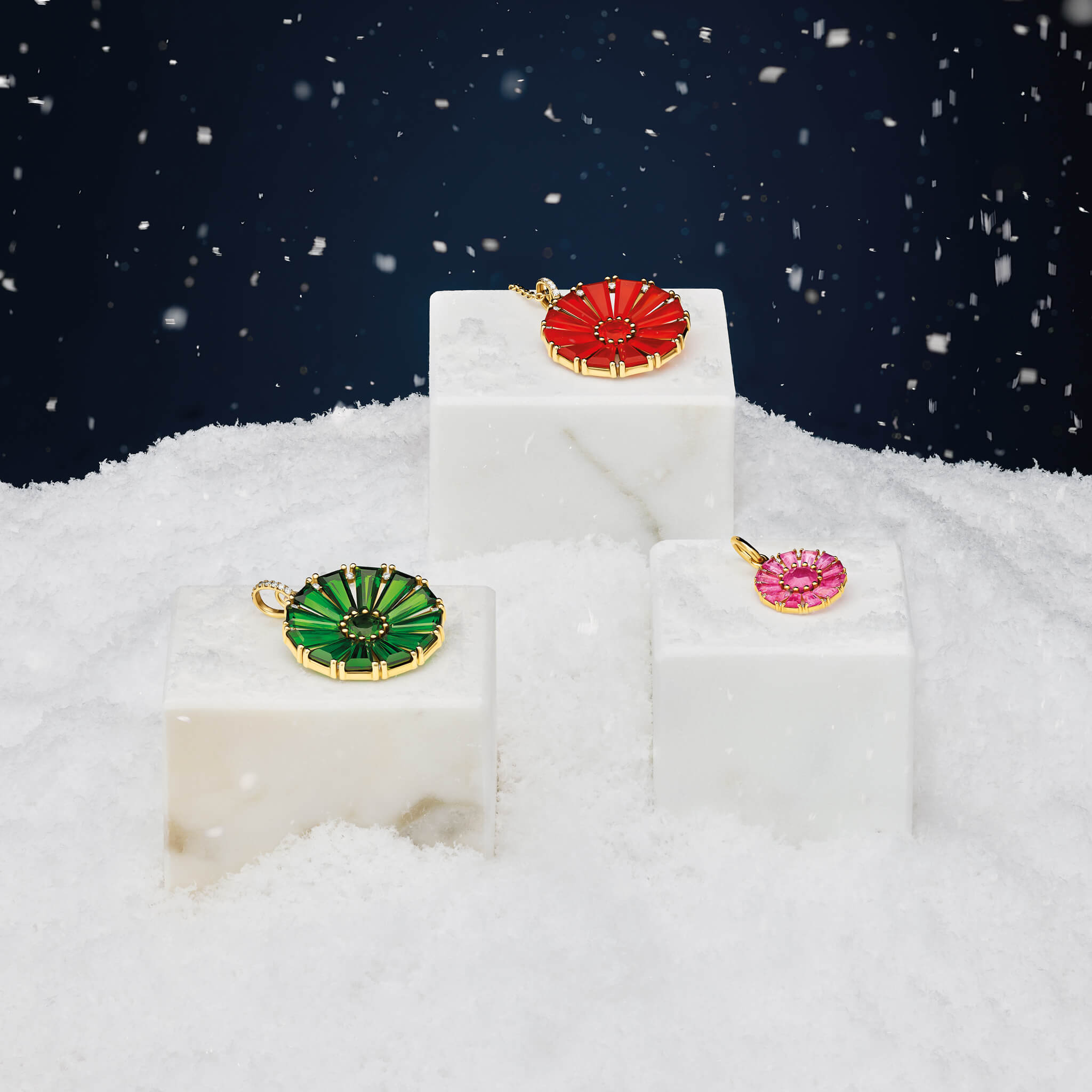 Three Roi Soleil necklace pendants in 9ct yellow gold with precious coloured gemstones and diamonds surrounded by a snowy scene.