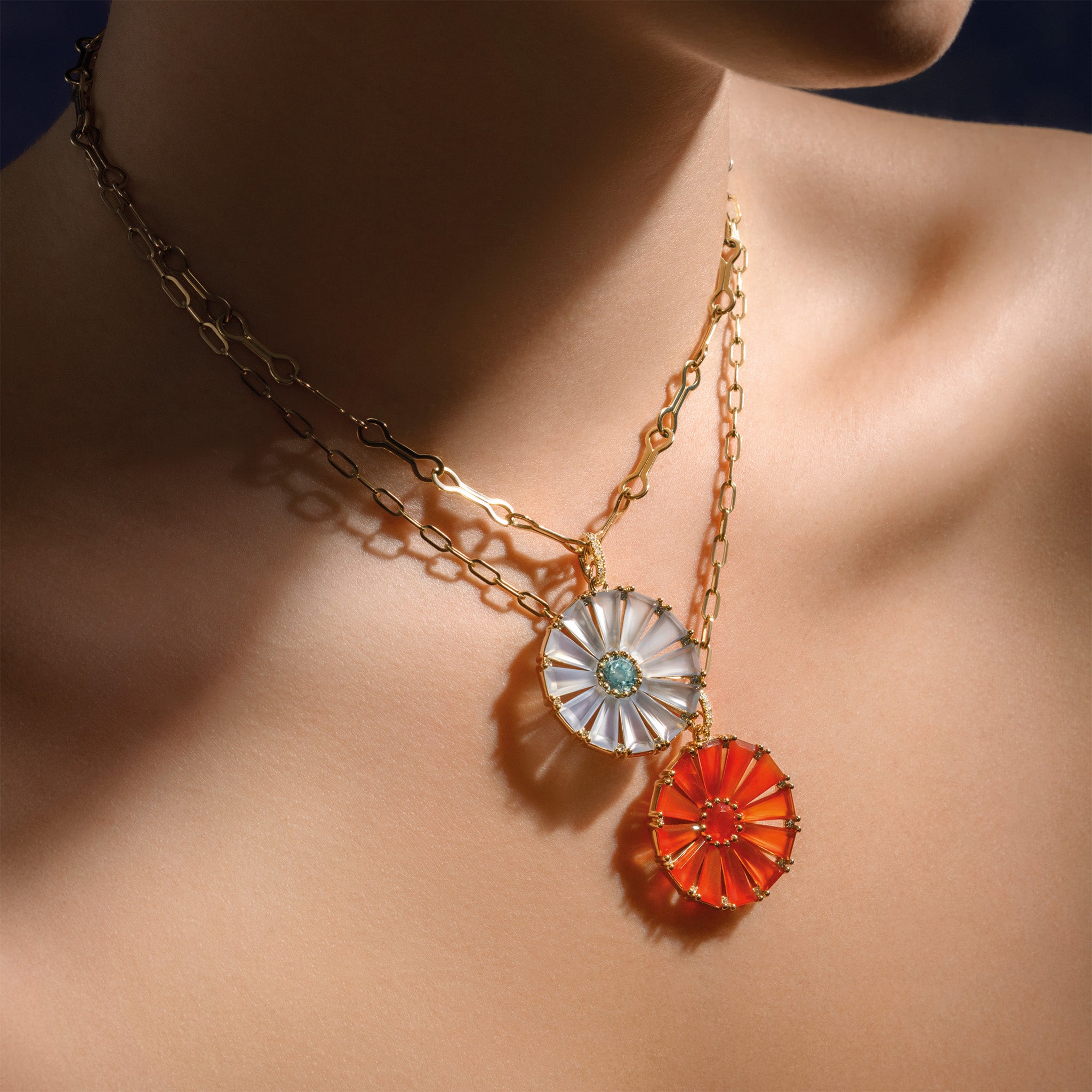 Model wearing a handcrafted yellow gold circular necklace pendant with baguette cut cornelian, fire opal and diamond gemstones.