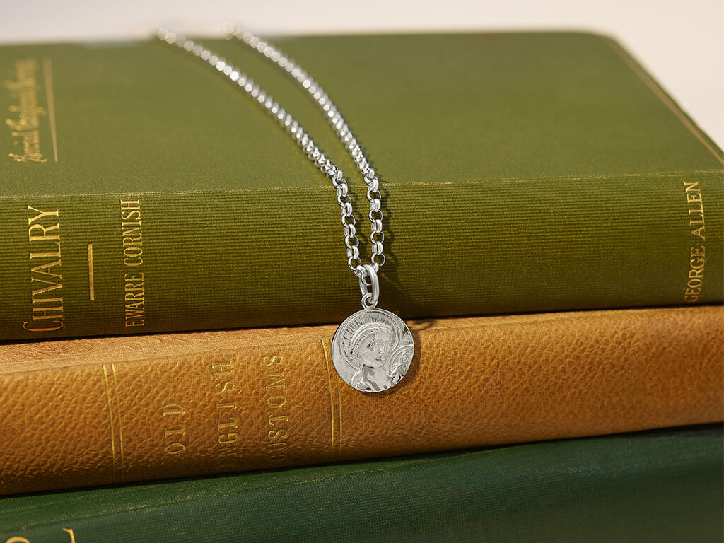 Cassandra Goad St pendant on pile of books