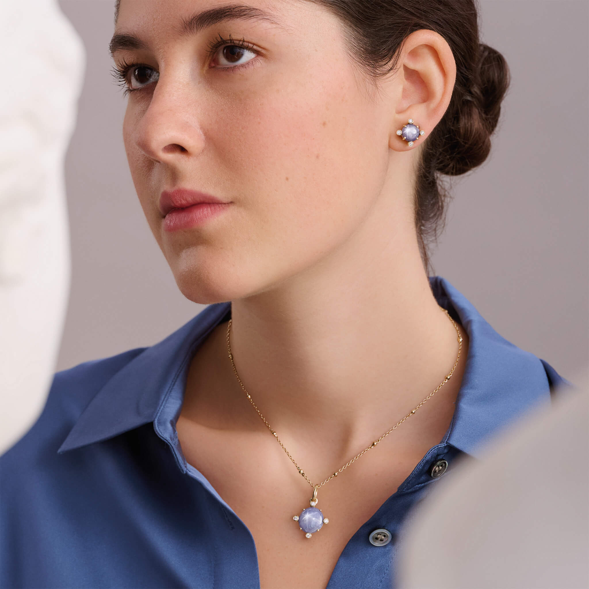Woman wearing handcrafted sapphire jewels, birthstone of September