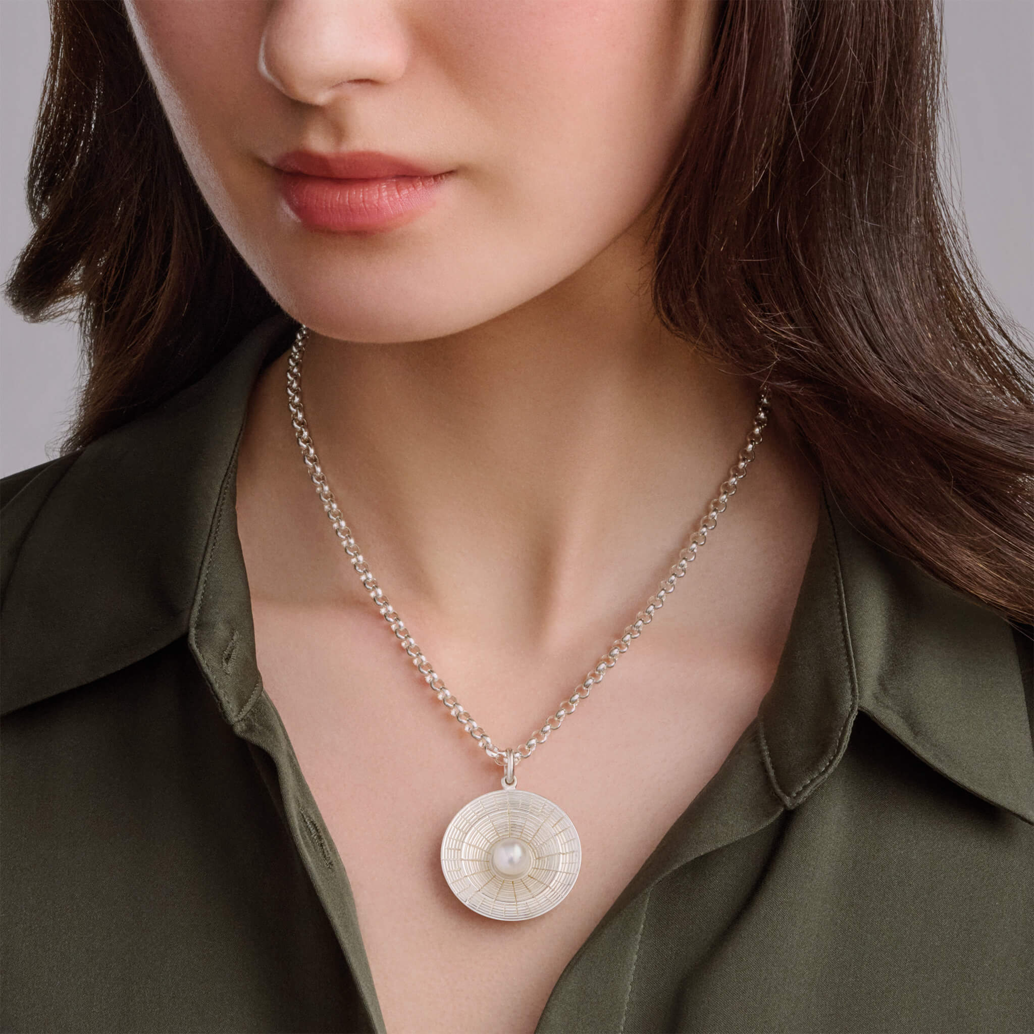 Model wears handcrafted Epidavros necklace pendant in precious metal with pearl, inspired by the ancient Greek amphitheatre of Epidaurus, june birthstone