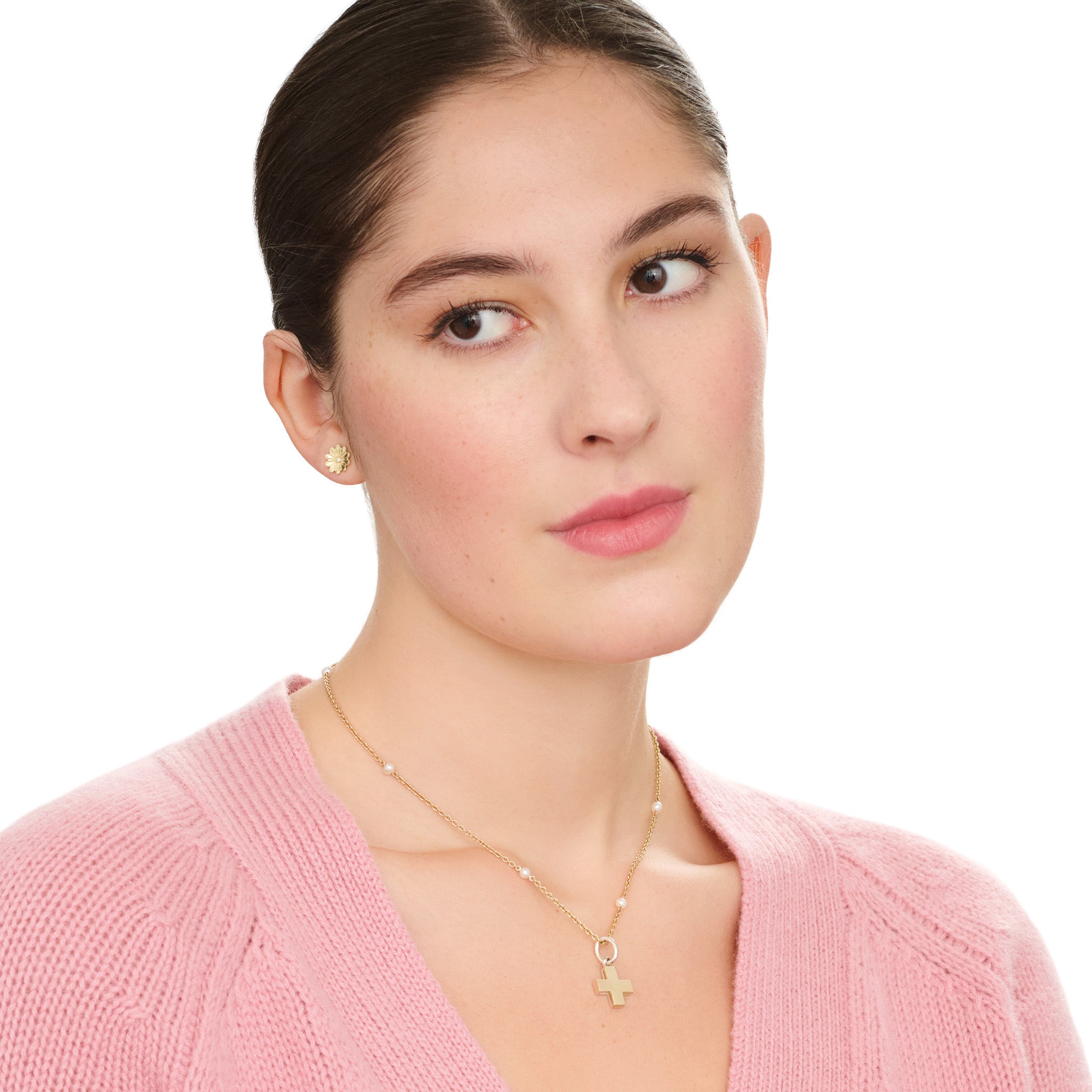 Model wearing handcrafted 9ct yellow gold and silver necklace pendant in a symmetrical cross shape.
