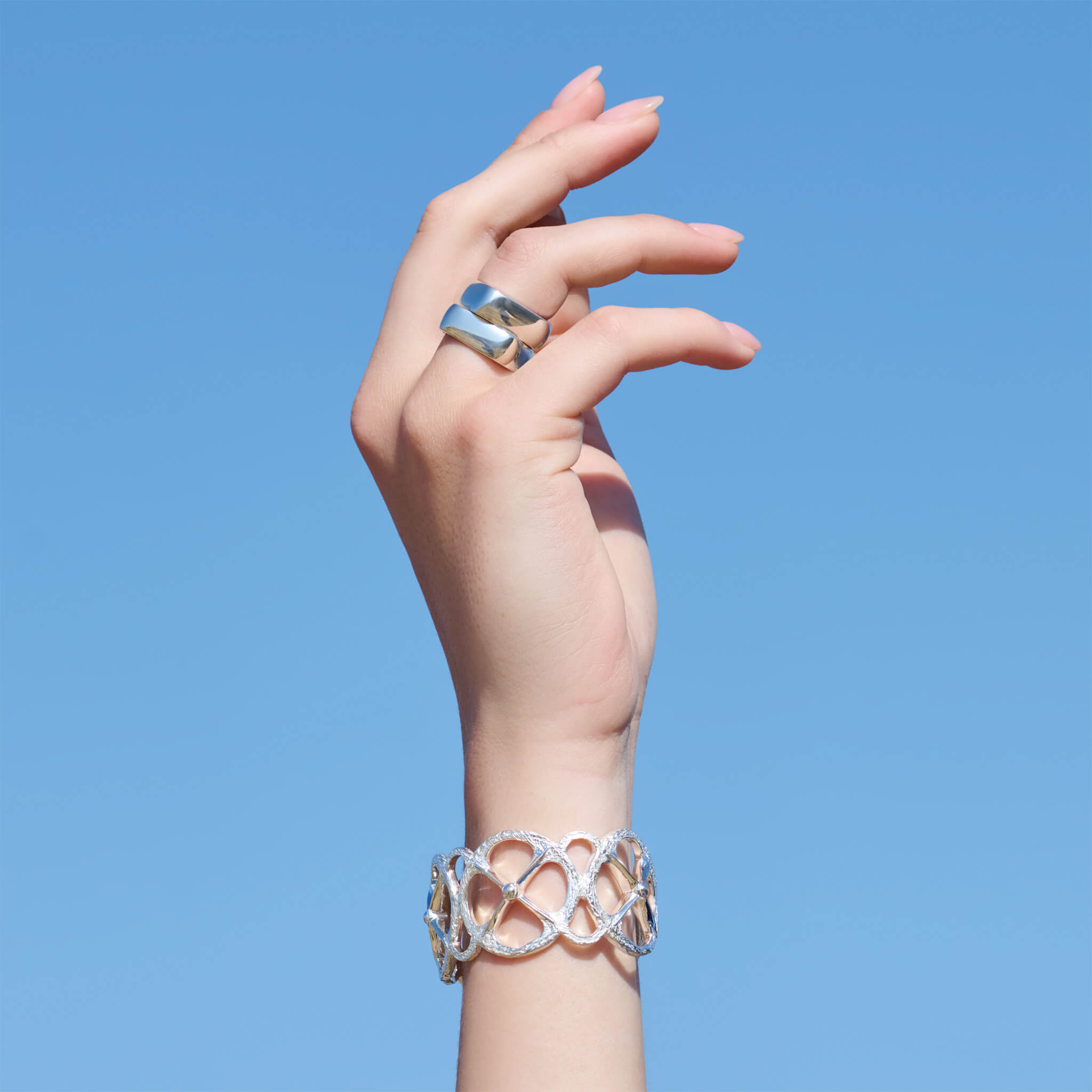 Model wears handcrafted silver square-shaped ring with rounded corners inspired by traditional Greek architecture, new launch